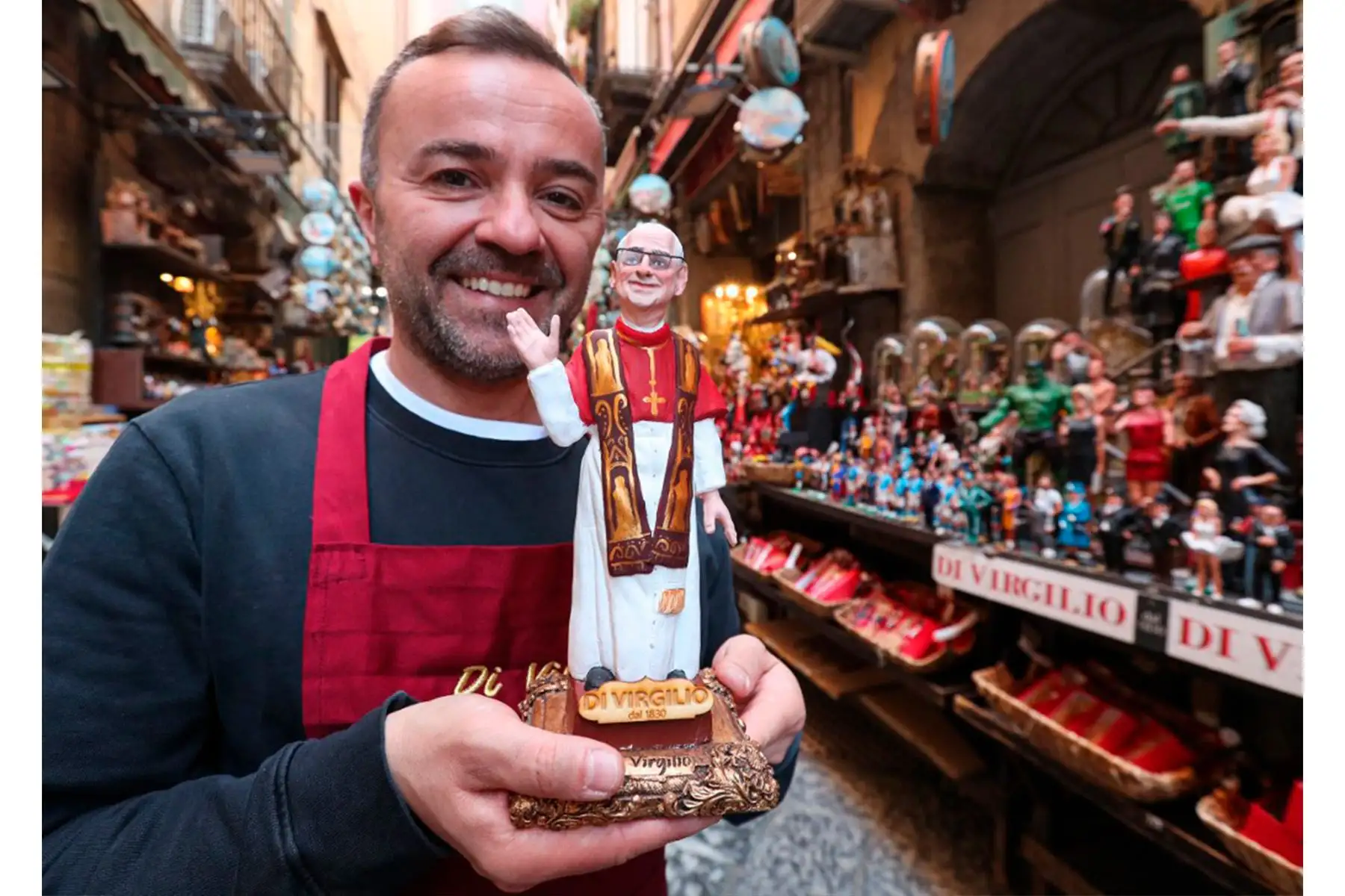 El artesano Gennaro Di Virgili posa con una estatua del recién elegido Papa León XIV frente a su tienda en el callejón San Gregorio Armeno, una calle donde los artesanos en Nápoles, Italia, el 9 de mayo de 2025. Foto: AFP