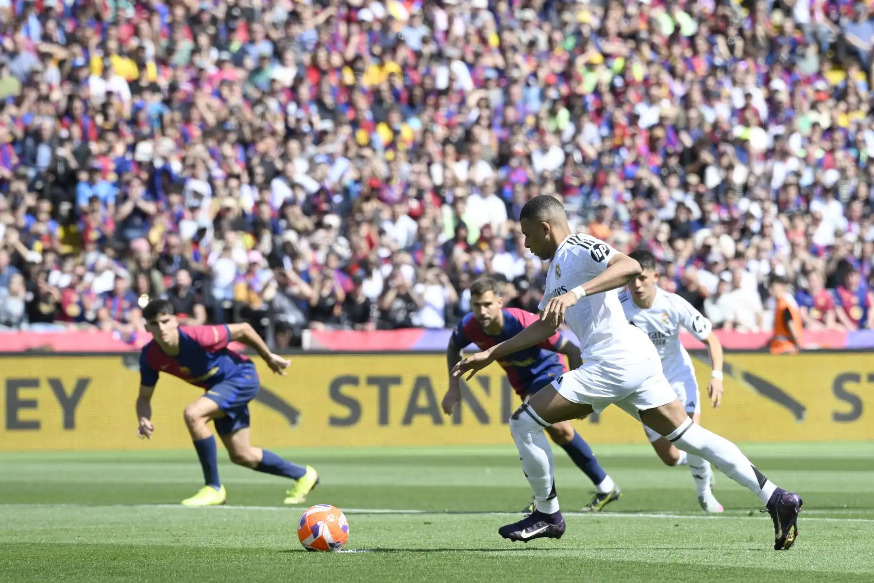 El delantero francés  del Real Madrid, Kylian Mbappé, dispara desde el punto de penalti para marcar su primer gol durante el partido de la liga española entre el FC Barcelona y el Real Madrid. AFP