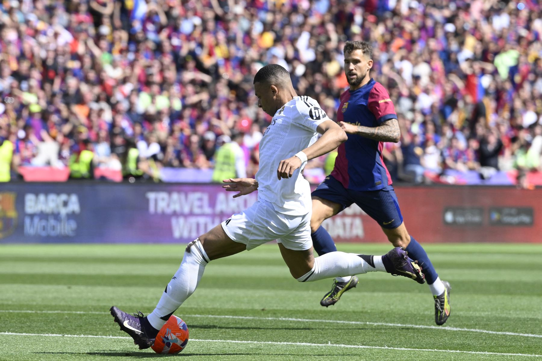 El delantero francés del Real Madrid, Kylian Mbappé, dispara para marcar su segundo gol durante el partido de fútbol de la liga española entre el FC Barcelona y el Real Madrid. AFP