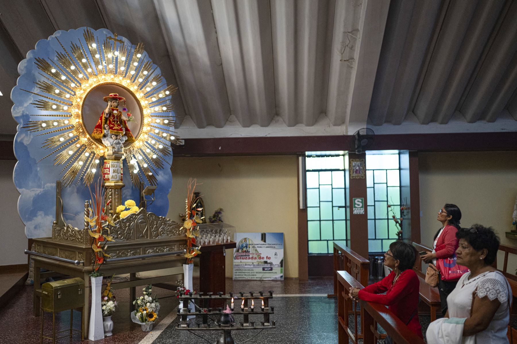 Fieles rezan ante la imagen del Divino Niño del Milagro, expuesta en la iglesia Santa María Magdalena del distrito de Eten, región Lambayeque, norte del Perú. AFP