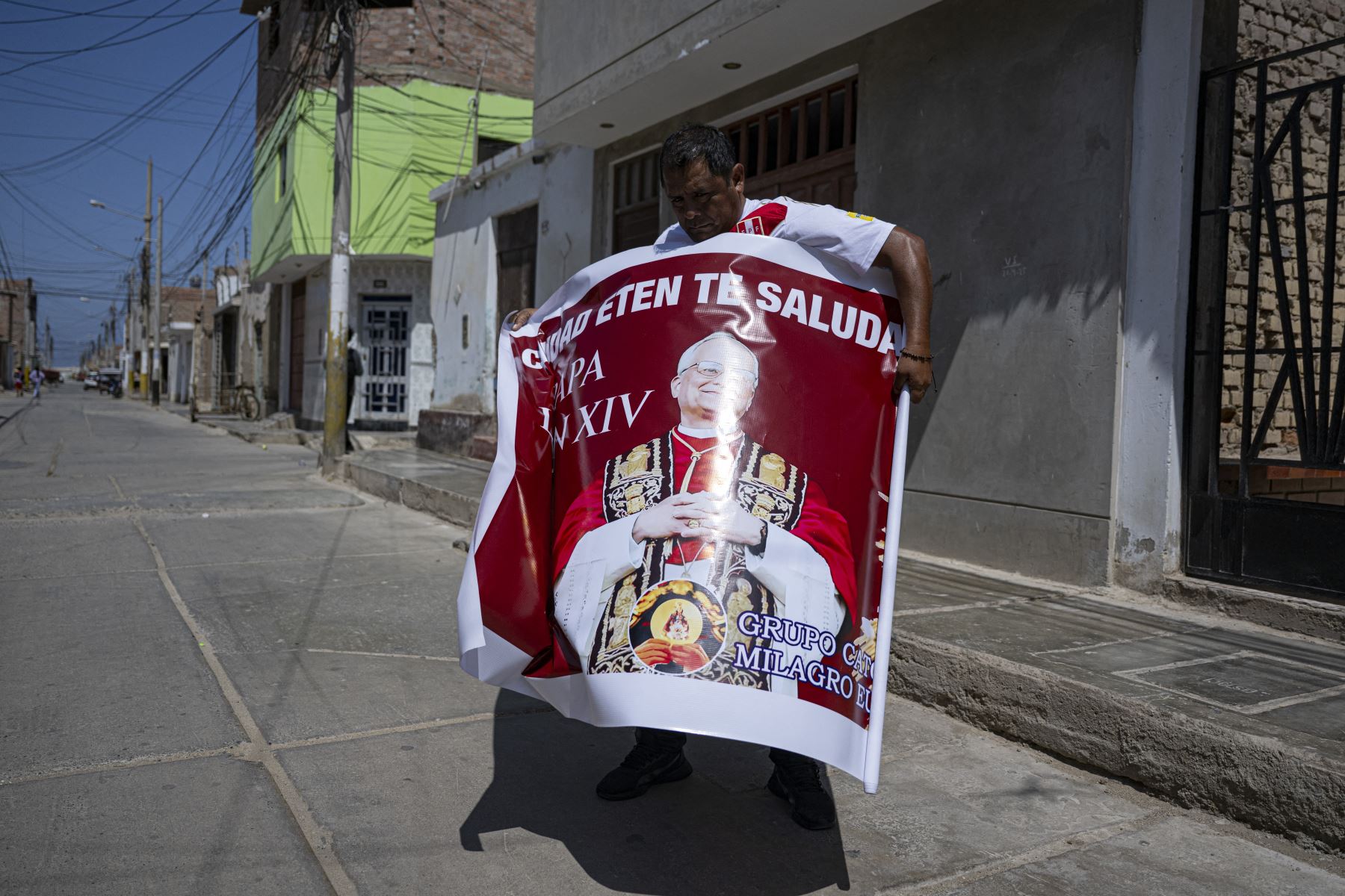 Un hombre despliega una pancarta con la imagen del Papa León XIV, distrito de Eten, región Lambayeque, norte del Perú. AFP