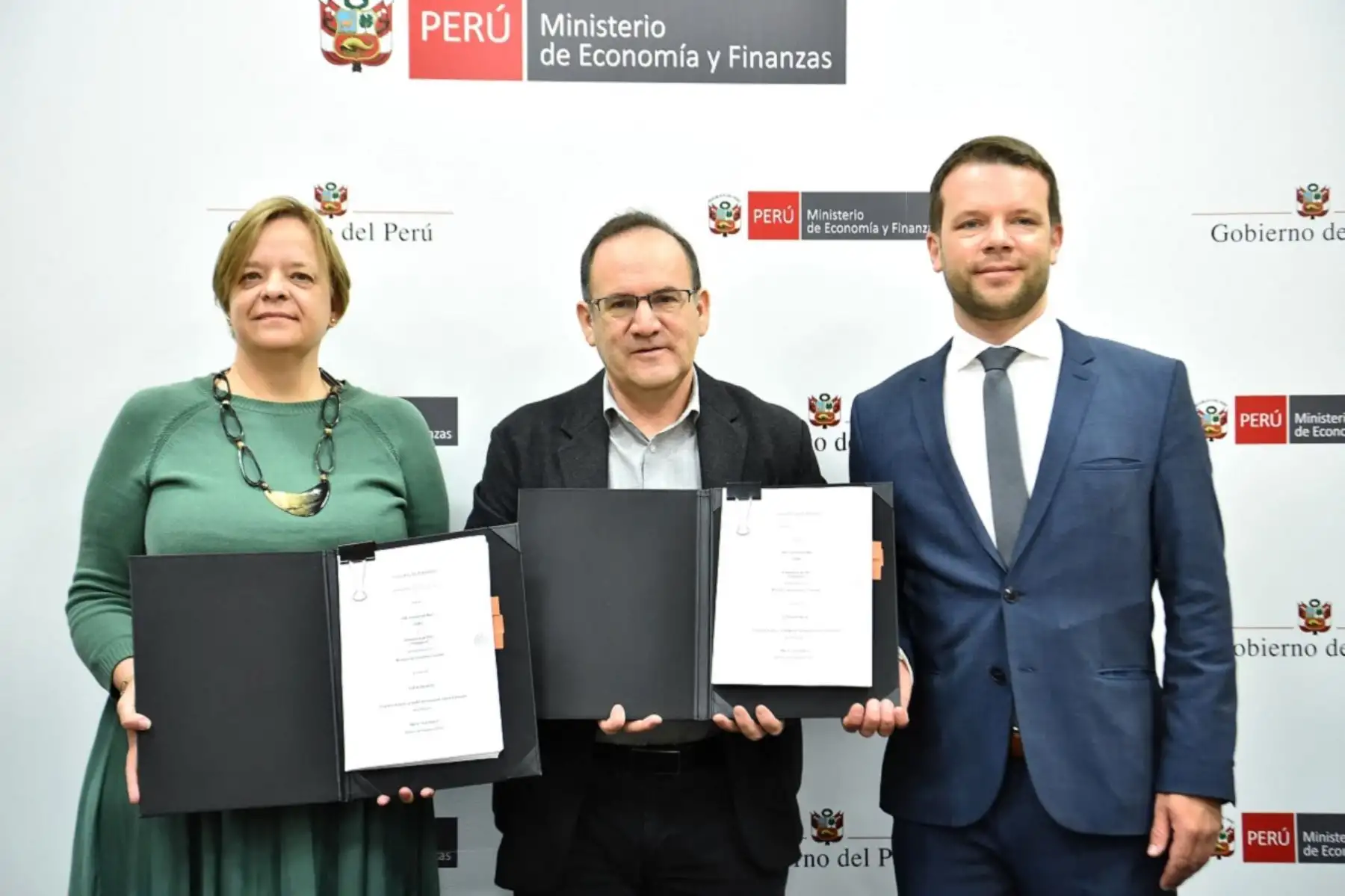 The German Ambassador to Peru, Sabine Bloch and the Minister of Economy and Finance, José Salardi Rodríguez, show the agreement signed, with the KfW Agency for Peru Simon Erhard. Photo: Courtesy.