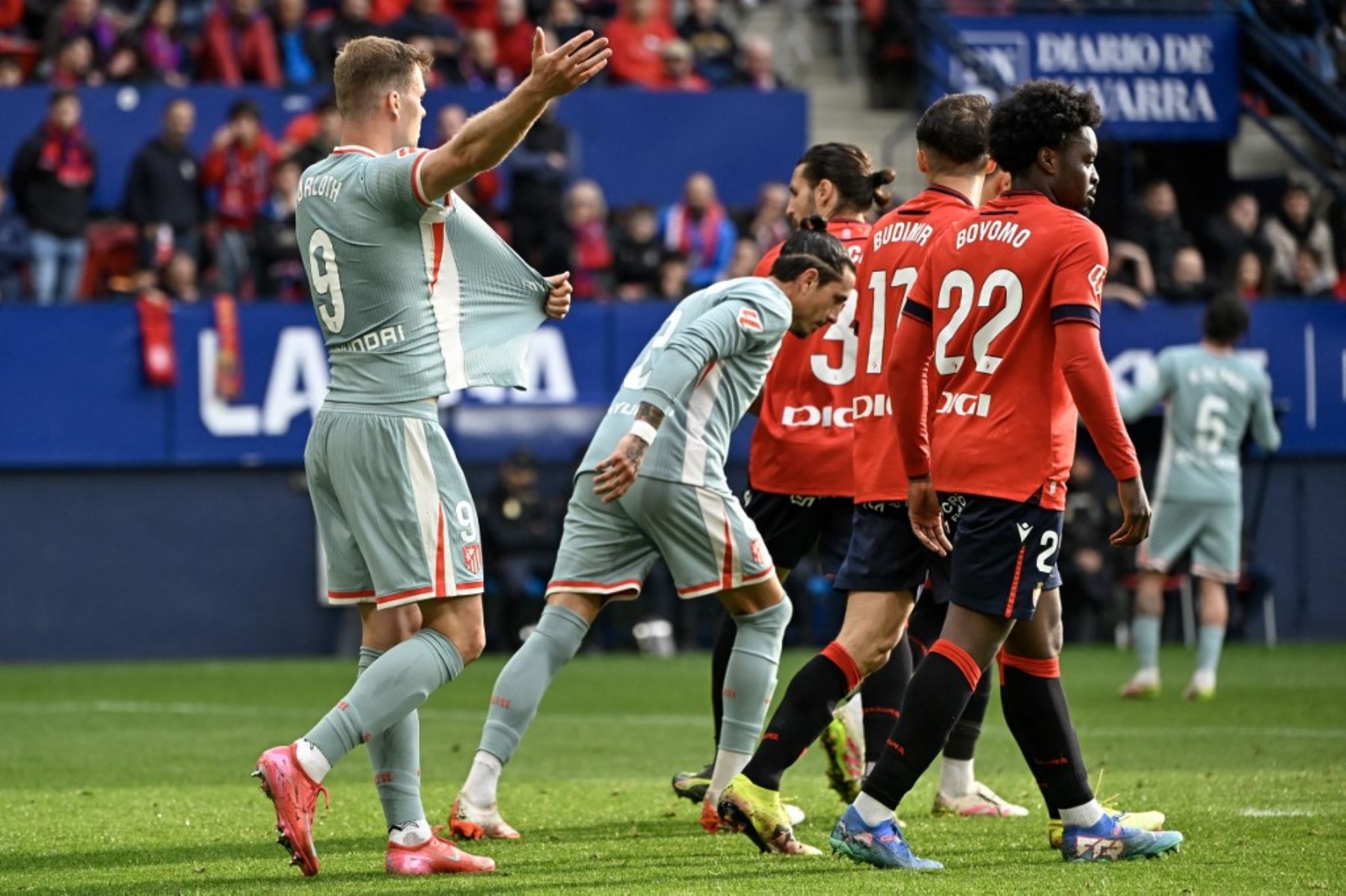 El delantero noruego del Atlético de Madrid #09 Alexander Sorloth (L) reacciona tirando de su camiseta al árbitro durante el partido de fútbol de la liga española entre CA Osasuna y Club Atlético de Madrid en el Estadio El Sadar de Pamplona, el 15 de mayo de 2025. (Foto de ANDER GILLENEA / AFP)