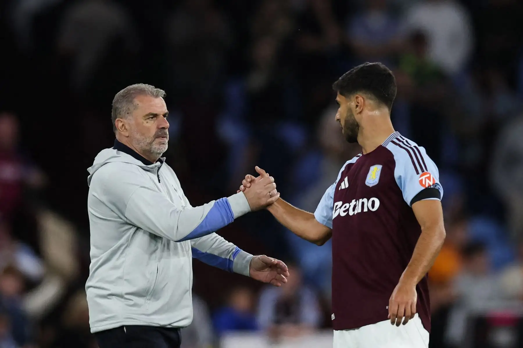 El entrenador greco-australiano del Tottenham Hotspur, Ange Postecoglou, estrecha la mano del centrocampista español del Aston Villa, Marco Asensio, al final del partido de la Premier League inglesa entre Aston Villa y Tottenham Hotspur en Villa Park en Birmingham, centro de Inglaterra, el 16 de mayo de 2025. Foto: AFP