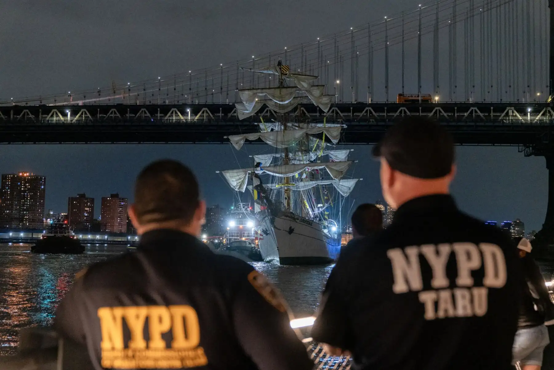 Integrantes del departamento de Policía de Nueva York observan el buque escuela mexicano Cuauhtémoc junto al puente de Brooklyn este sábado, en Nueva York. EFE
