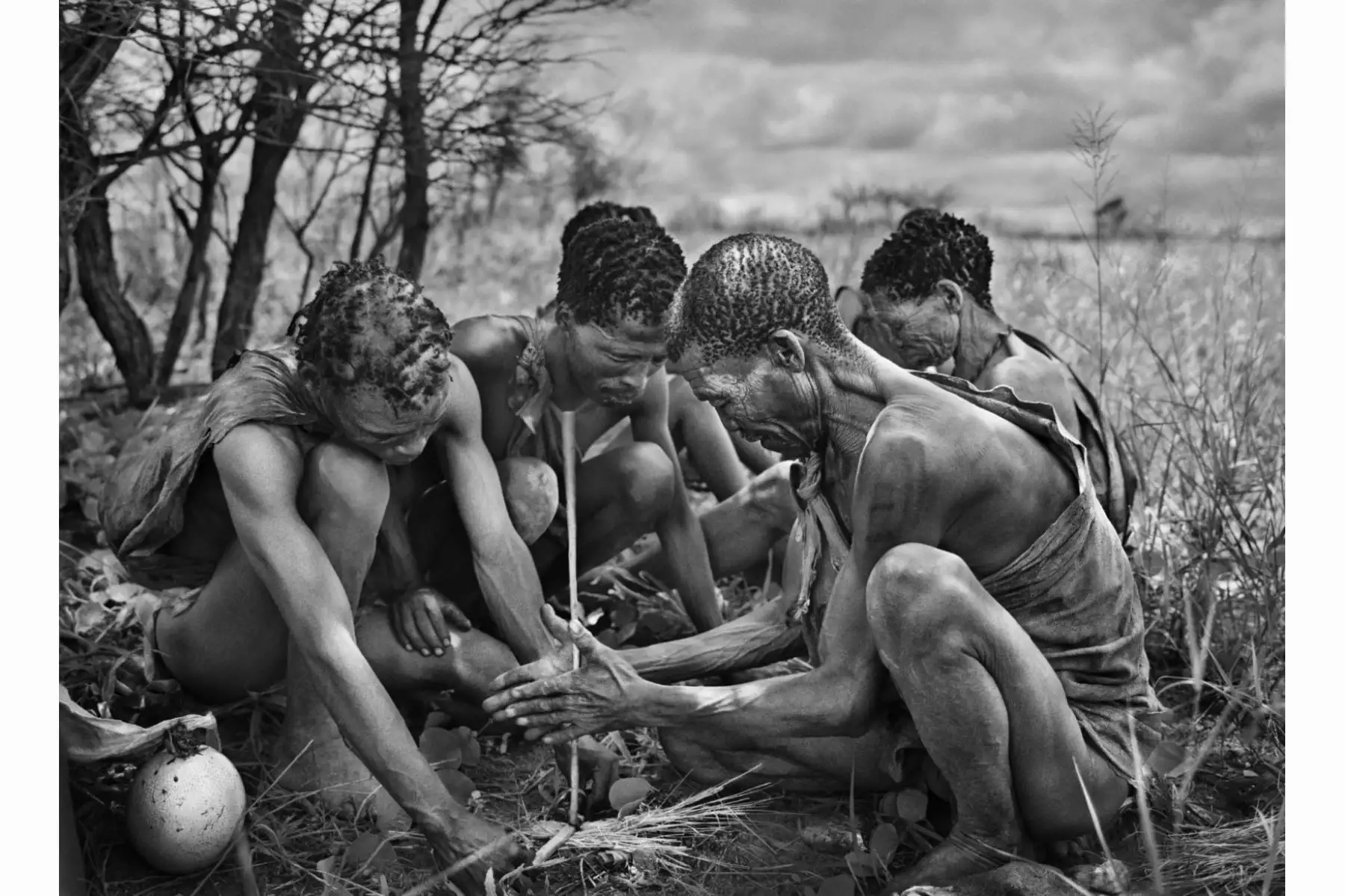 Bosquimanos en el desierto del Kalahari (Botswana) en 2008. Sebastiao Salgado les fotografía desde muy corta distancia mientras hacen fuego del mismo modo que sus ancestros más remotos, ya que los miembros de esta tribu llevan viviendo de modo idéntico desde el Paleolítico Superior. © Sebastiao Salgado / Amazonas Images
