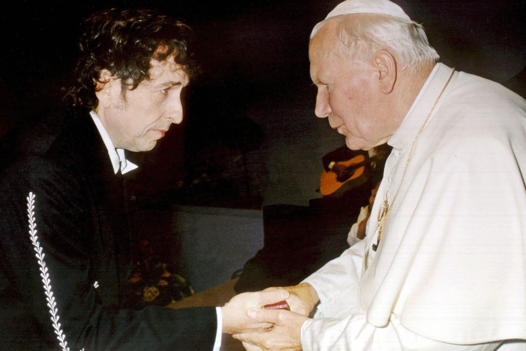 Imagen difundida el 29 de septiembre por el Vaticano del Papa Juan Pablo II (R) saludando al baladista estadounidense Bob Dylan después de su actuación en un concierto durante un encuentro de la juventud católica en la ciudad de Bolonia el 27 de septiembre, al que asistió el pontífice. AFP