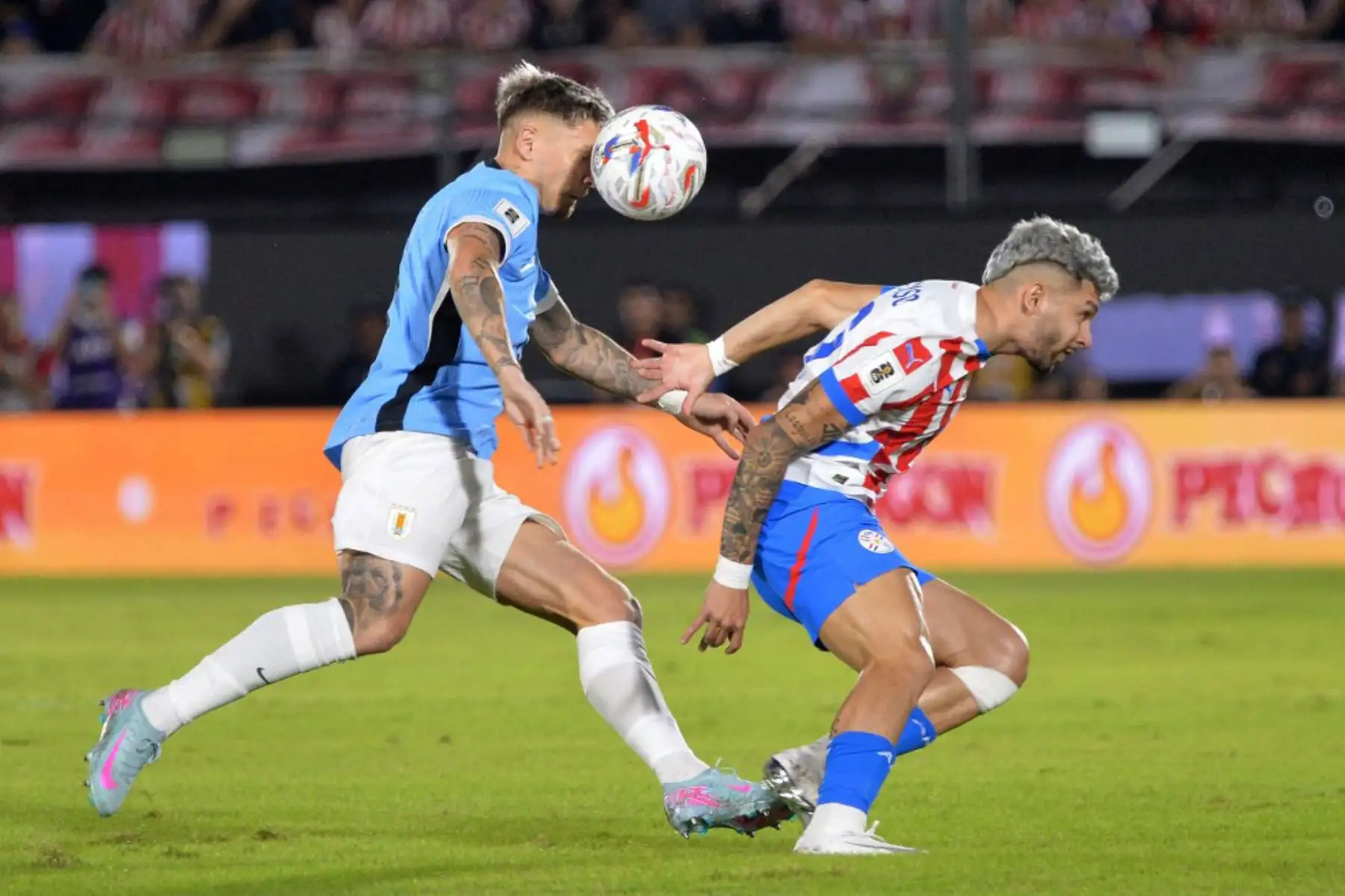 El defensor de Uruguay, Guillermo Varela, y el delantero de Paraguay, Julio Enciso, luchan por el balón durante el partido de fútbol de las eliminatorias sudamericanas de la Copa Mundial de la FIFA 2026 entre Paraguay y Uruguay en el estadio Defensores del Chaco en Asunción el 5 de junio de 2025. Foto: AFP