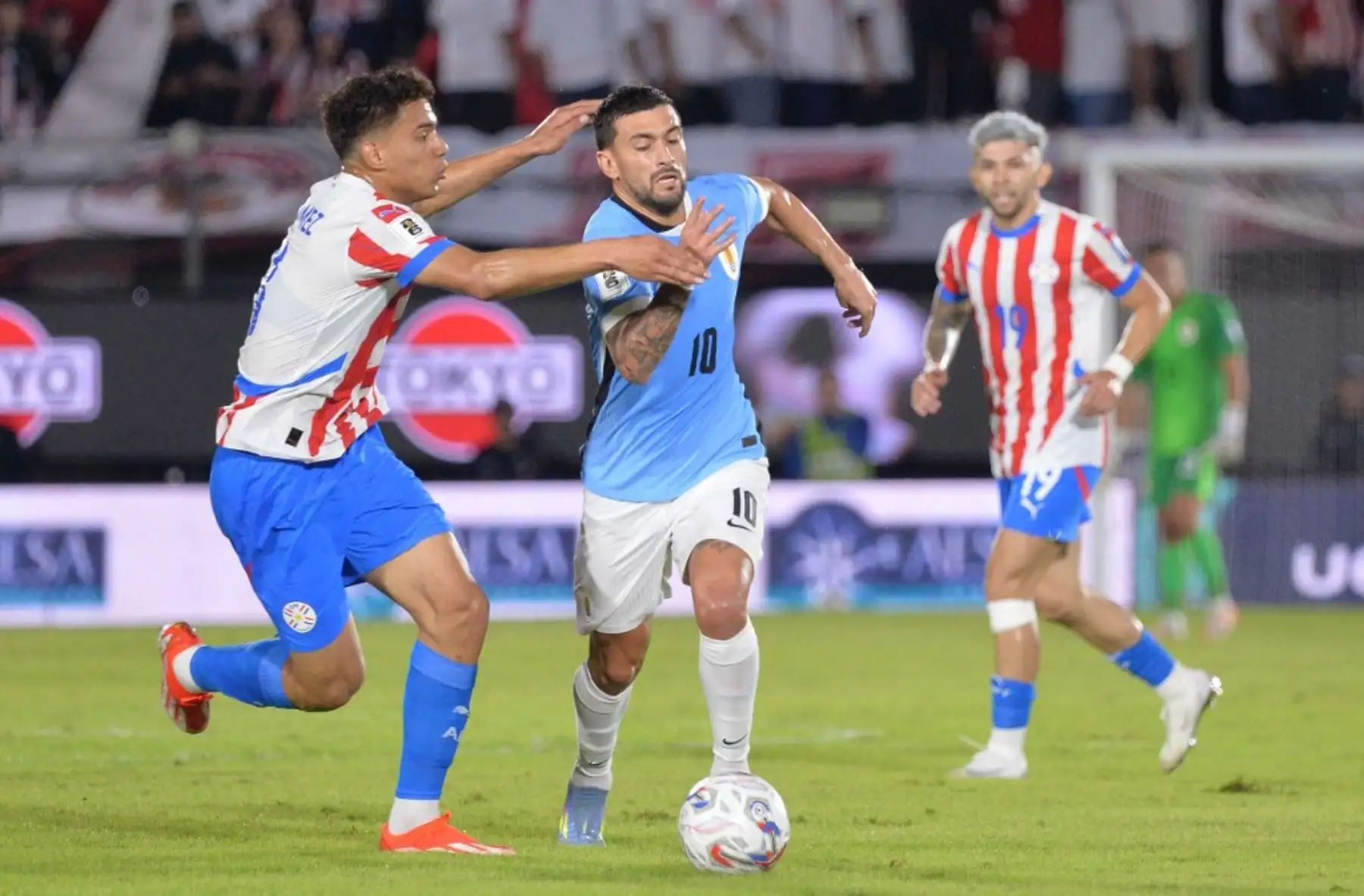 El mediocampista de Paraguay, Diego Gómez, y el mediocampista de Uruguay, Giorgian de Arrascaeta, luchan por el balón durante el partido de fútbol de las eliminatorias sudamericanas de la Copa Mundial de la FIFA 2026 entre Paraguay y Uruguay en el estadio Defensores del Chaco en Asunción el 5 de junio de 2025. Foto: AFP