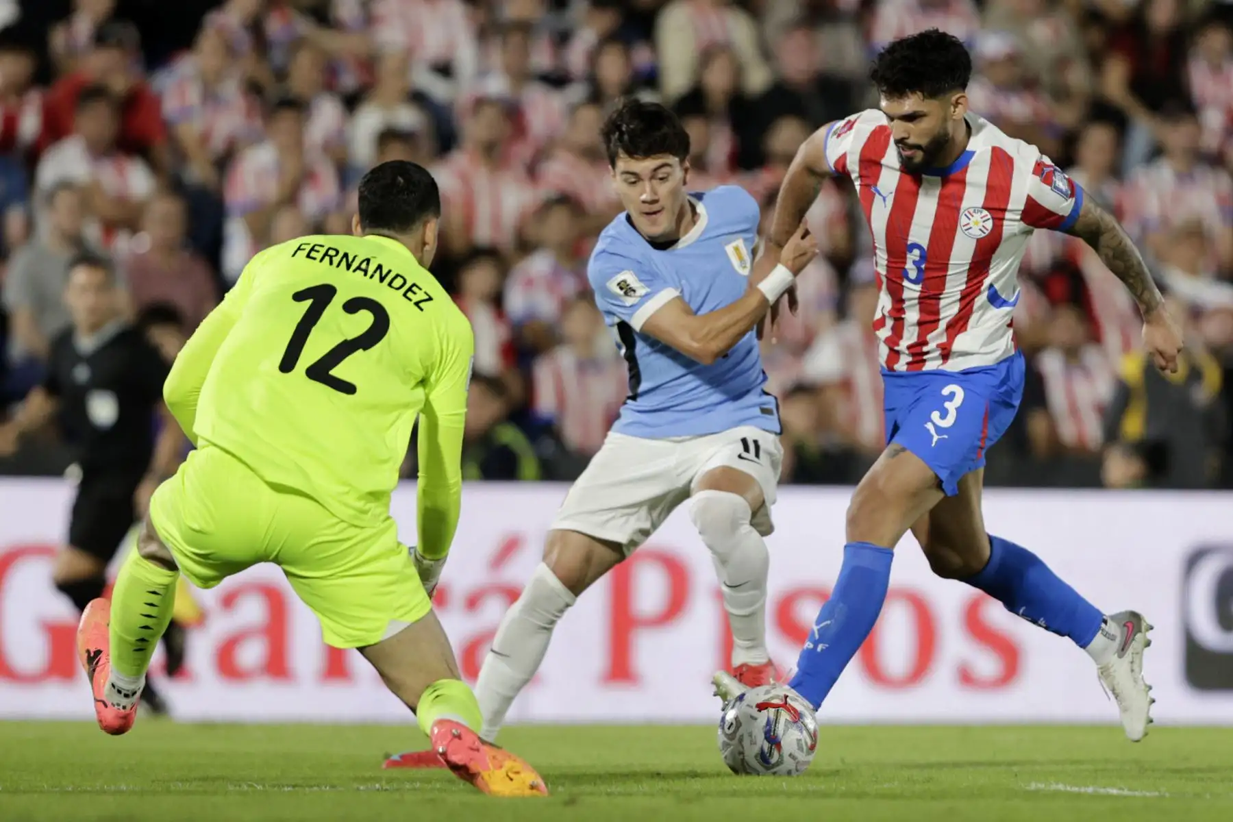 Omar Alderete de Paraguay disputa el balón con Facundo Pellistri de Uruguay este jueves, durante el partido de las eliminatorias sudamericanas para el Mundial de 2026 entre las selecciones Paraguay y Uruguay en el estadio Defensores del Chaco en Asunción. Foto: EFE