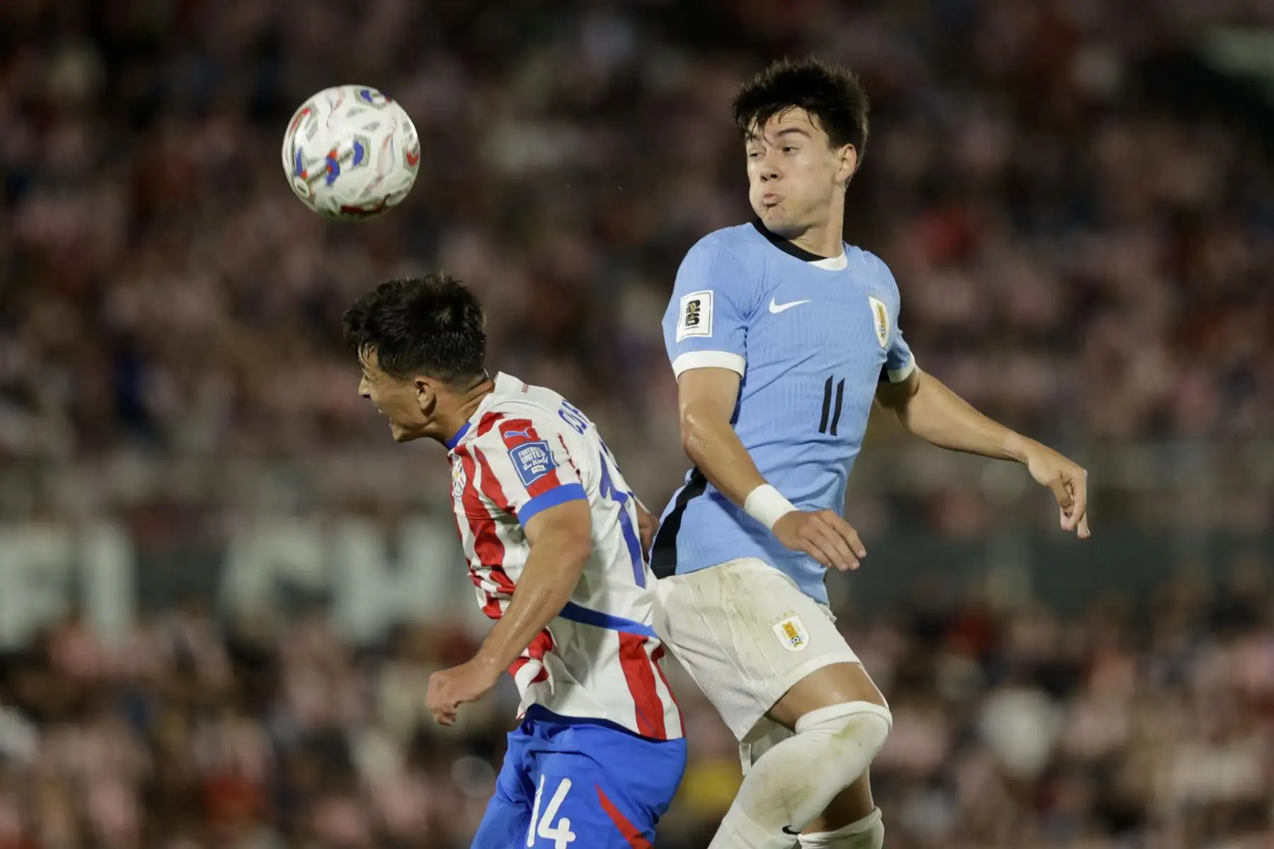Andrés Cubas de Paraguay disputa el balón con Facundo Pellistri de Uruguay este jueves, durante el partido de las eliminatorias sudamericanas para el Mundial de 2026 entre las selecciones Paraguay y Uruguay en el estadio Defensores del Chaco en Asunción. Foto: EFE