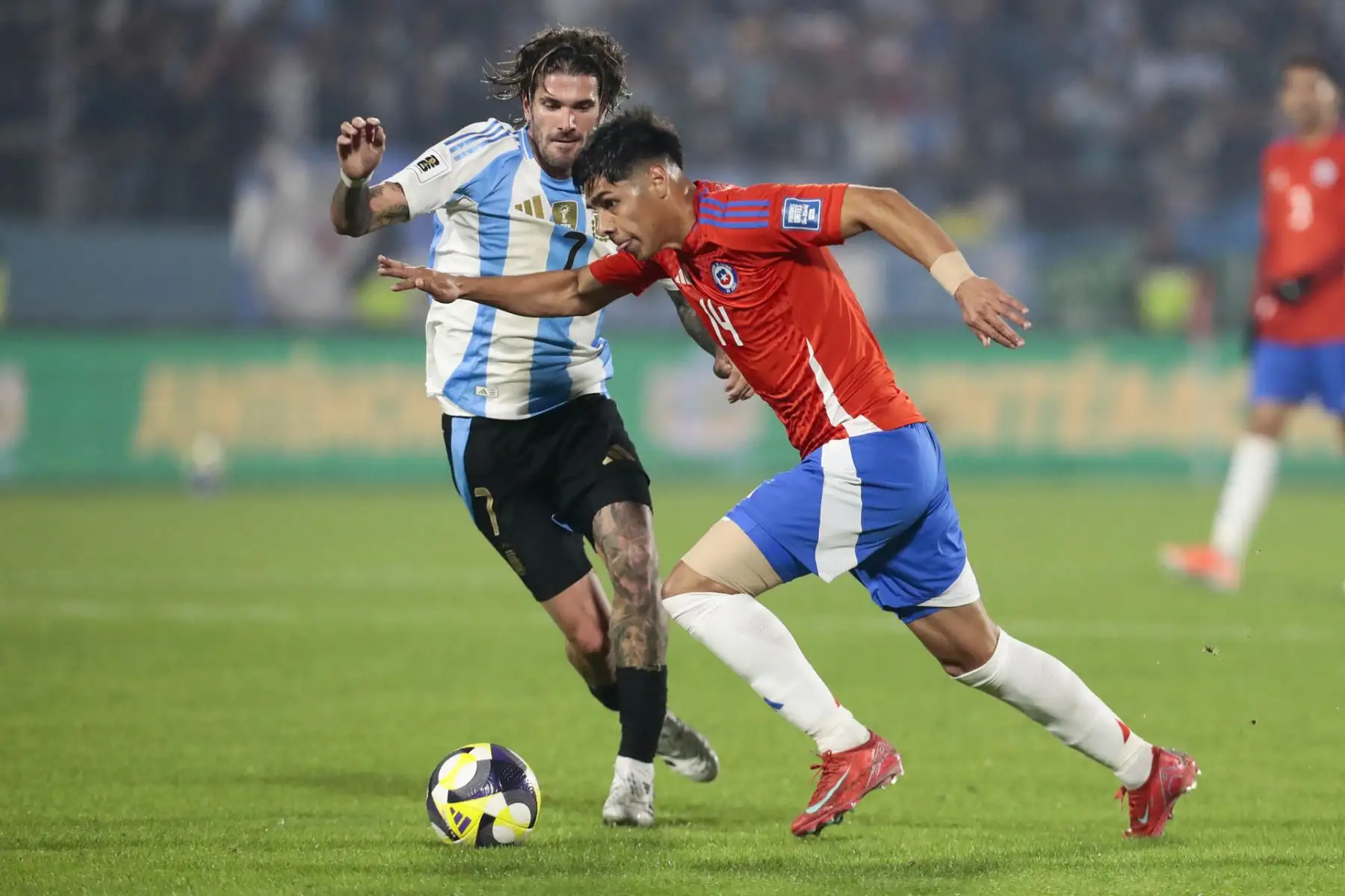 Darío Osorio de Chile disputa el balón con Rodrigo de Paul de Argentina este jueves, durante el partido de las eliminatorias sudamericanas para el Mundial de 2026 entre las selecciones de Chile y Argentina en el estadio Nacional Julio Martínez Prádanos en Santigo de Chile. Foto: EFE