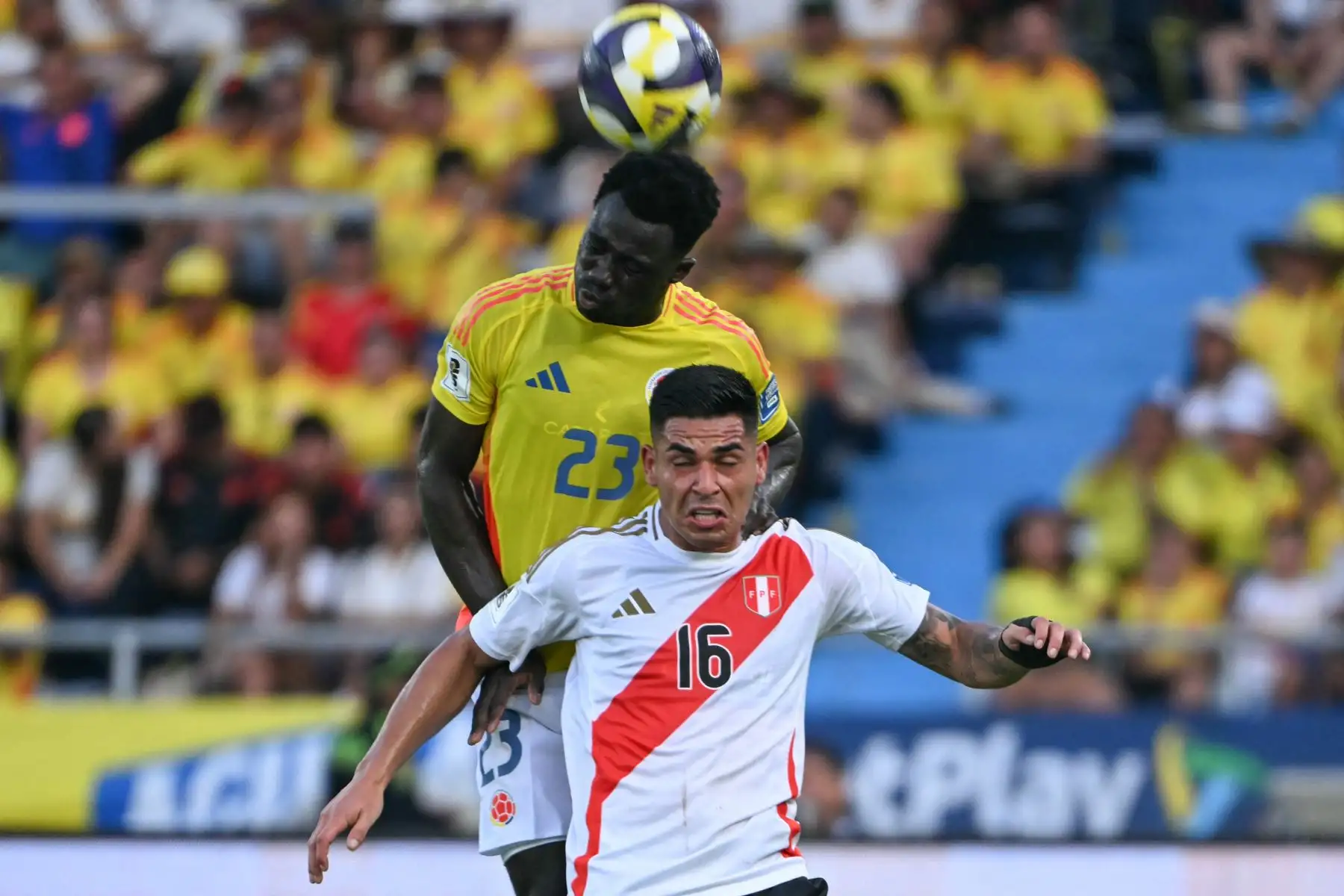 El defensa colombiano Davinson Sánchez cabecea el balón y supera al delantero peruano  Luis Ramos durante el partido de clasificación sudamericana para la Copa Mundial de la FIFA 2026 entre Colombia y Perú. AFP