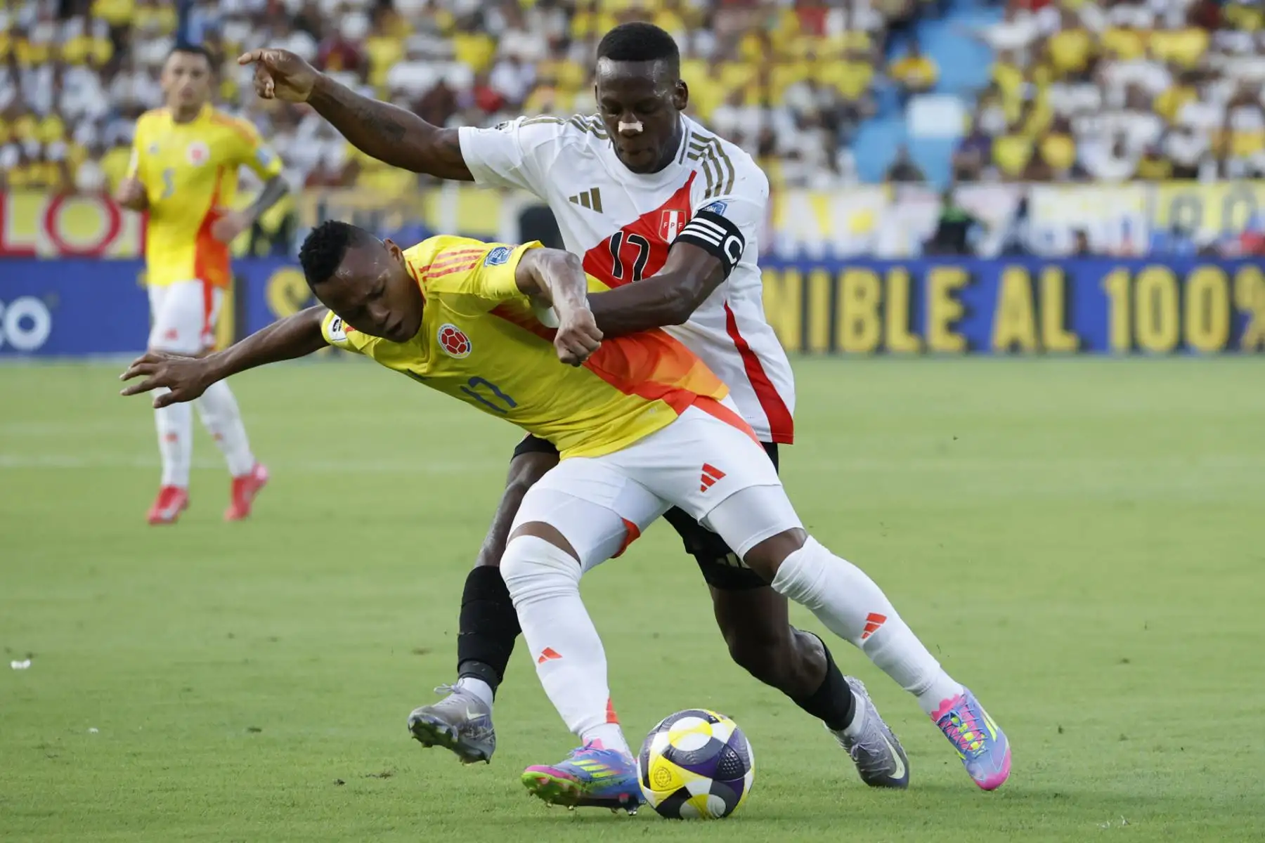 Jáminton Campaz de Colombia disputa el balón con Luis Advíncula de Perú este viernes, en un partido por las eliminatorias sudamericanas para el Mundial 2026 entre las selecciones de Colombia y Perú. EFE