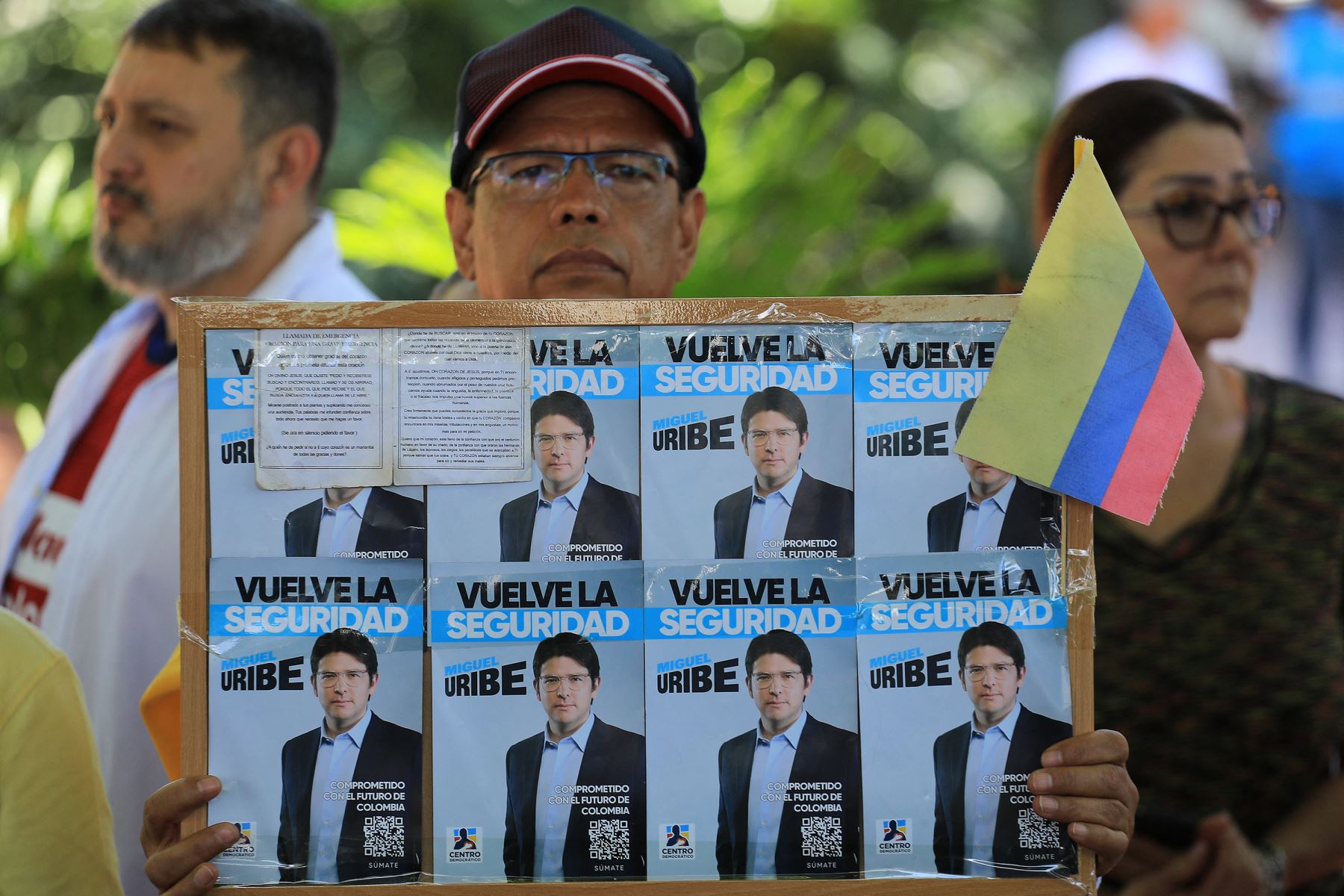 Un hombre sostiene un cartel con propaganda del candidato presidencial Miguel Uribe durante una protesta contra la violencia y a favor de la paz en Medellín, Colombia.
Foto: AFP