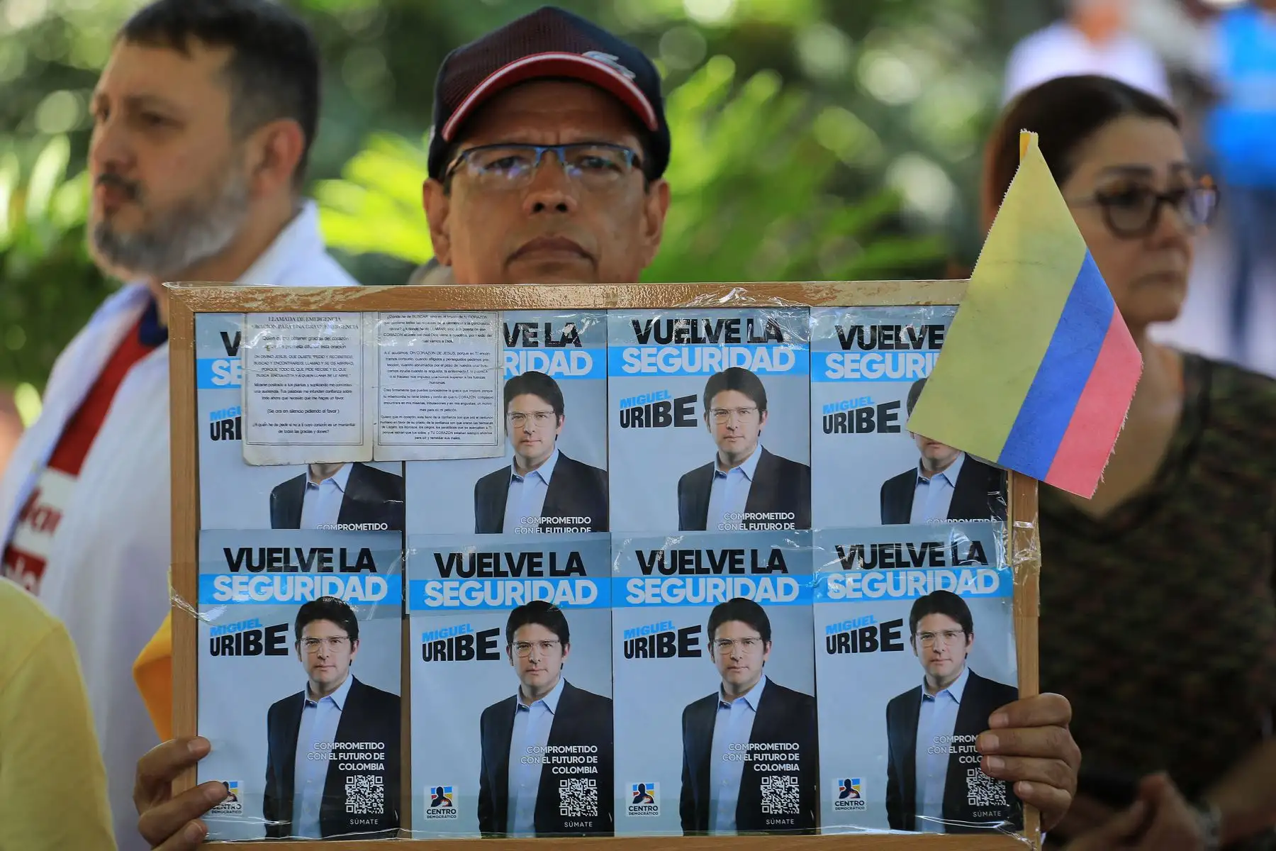 Un hombre sostiene un cartel con propaganda del candidato presidencial Miguel Uribe durante una protesta contra la violencia y a favor de la paz en Medellín, Colombia.
Foto: AFP