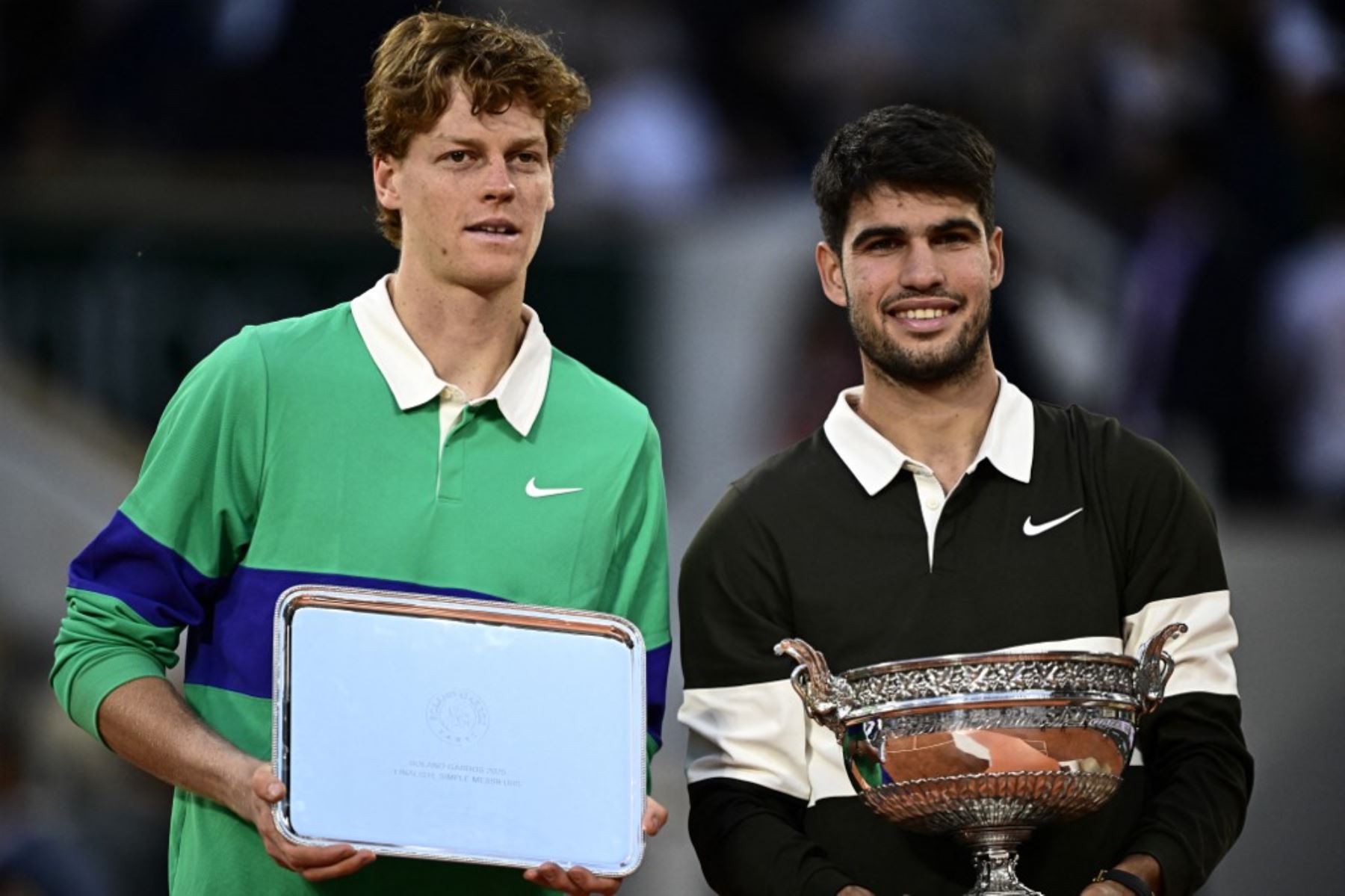 El ganador de España Carlos Alcaraz (R) posa con el trofeo junto al italiano Jannik Sinner al final de su partido final de individuales masculinos el día 15 del torneo de tenis Abierto de Francia en la cancha Philippe-Chatrier en el Complejo Roland-Garros de París el 8 de junio de 2025. (Foto de JULIEN DE ROSA / AFP)