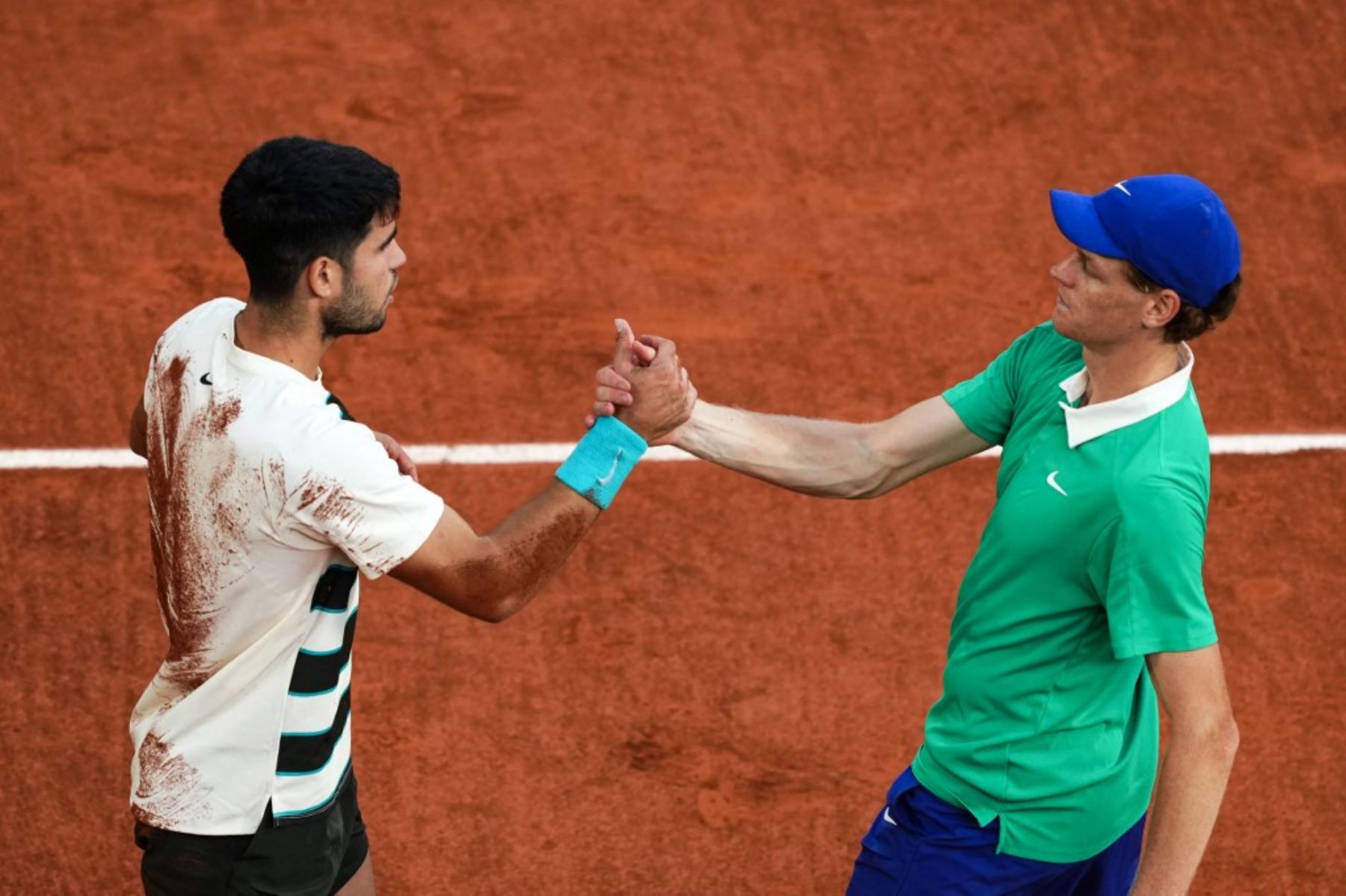 El español Carlos Alcaraz (izquierda) estrecha la mano del italiano Jannik Sinner después de ganar el partido final de individuales masculinos en el día 15 del torneo de tenis del Abierto de Francia en la cancha Philippe-Chatrier en el Complejo Roland-Garros de París el 8 de junio de 2025. (Foto de Dimitar DILKOFF / AFP)