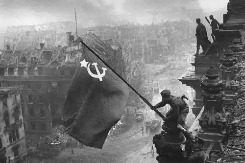 "Bandera de la victoria sobre el Reichstag", icónica fotografía tomada por el corresponsal de guerra soviético Evguéni A. Jaldéi el 2 de mayo de 1945, muestra a soldados soviéticos izando la bandera de la Unión Soviética sobre el edificio semidestruido del Reichstag en Berlín. Esta imagen, que simboliza la victoria soviética, fue una recreación de la toma de Berlín por parte de los soviéticos, y es una de las fotografías más representativas de la Segunda Guerra Mundial. Foto: ANDINA/Evguéni Jaldéi