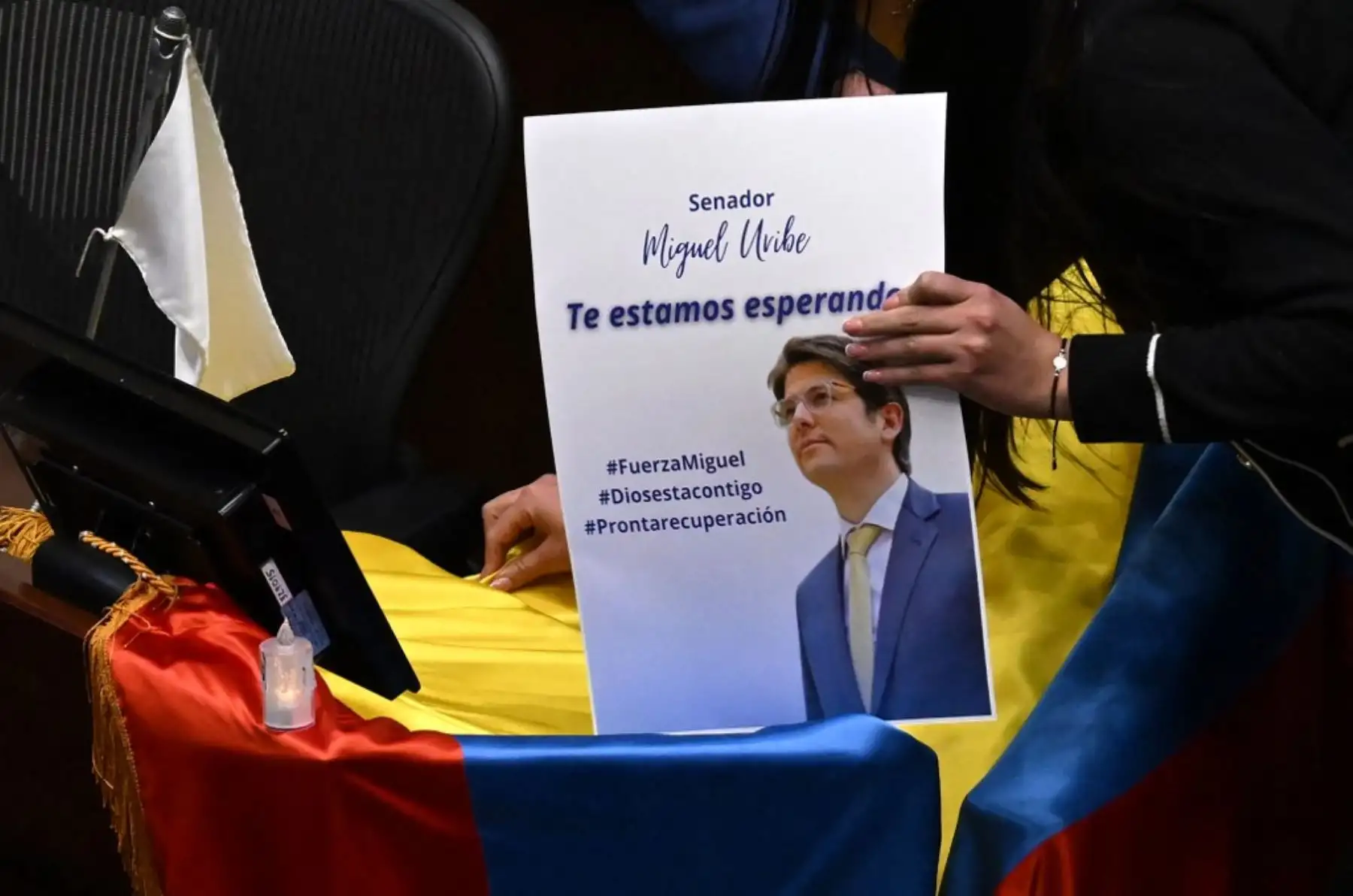 Legisladores colocan una foto del senador y candidato presidencial colombiano Miguel Uribe con la frase "Te esperamos" en una bandera colombiana sobre su escaño en el Congreso en Bogotá el 9 de junio de 2025. Foto: AFP