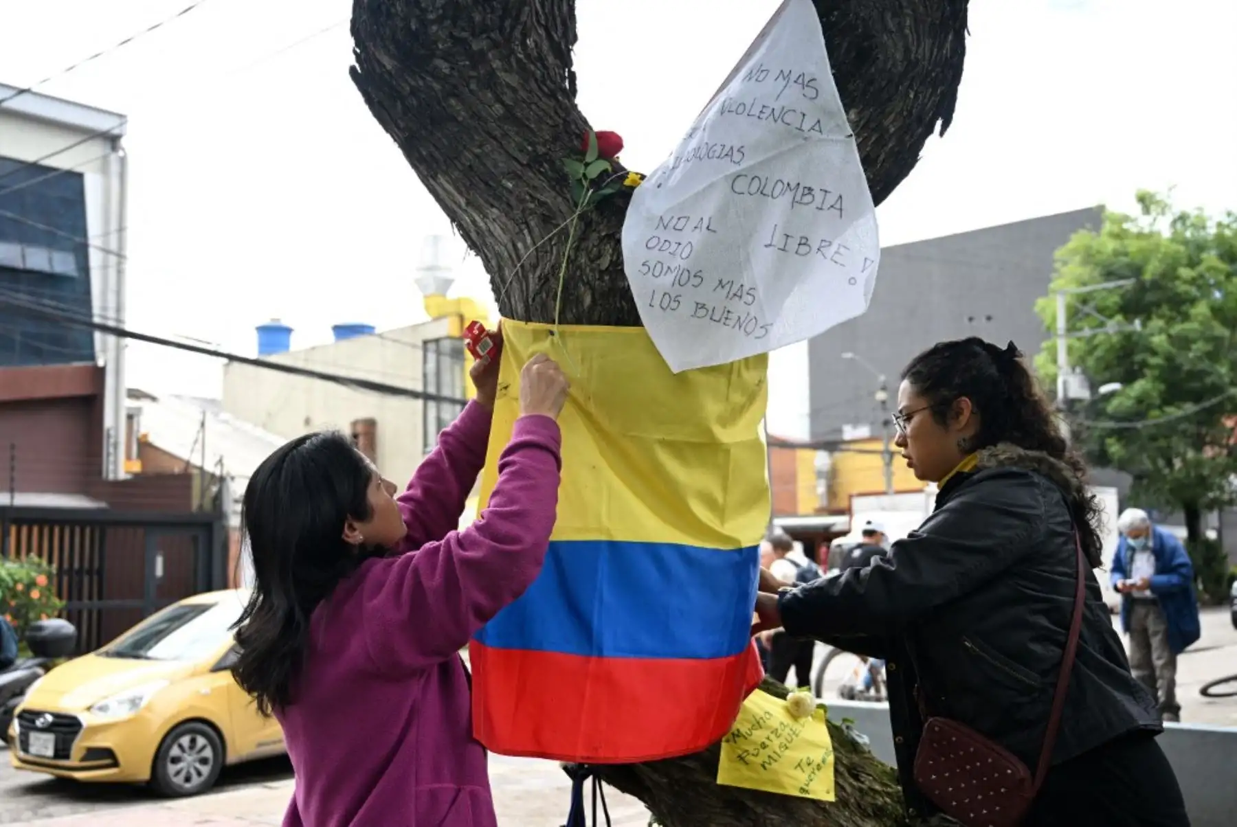 Mujeres sostienen una bandera colombiana en el lugar donde el senador Miguel Uribe Turbay fue baleado y herido en un acto político el pasado sábado en Bogotá el 9 de junio de 2025. Foto: AFP