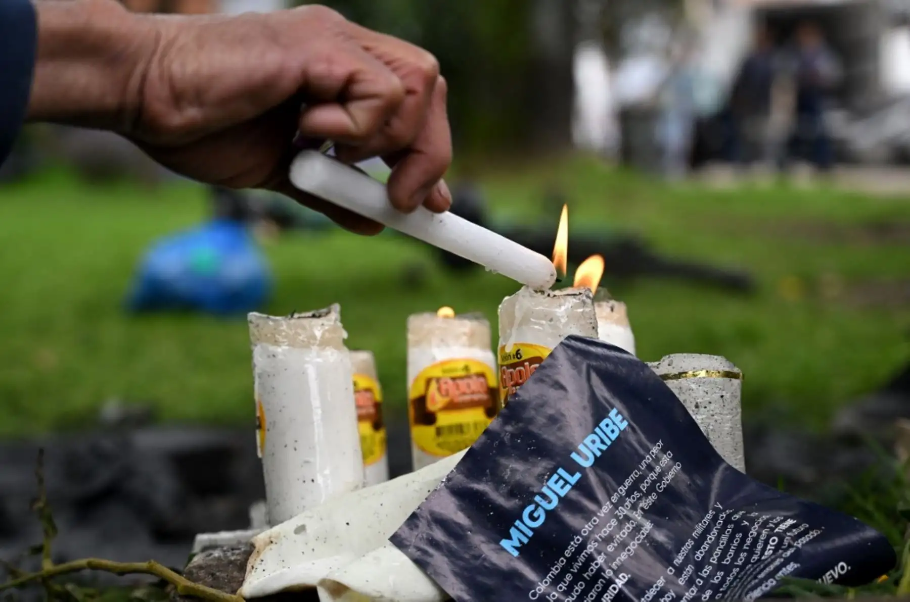 Una persona enciende una vela en el lugar donde el senador Miguel Uribe Turbay fuera baleado y herido en un acto político el pasado sábado en Bogotá el 9 de junio de 2025. Foto: AFP