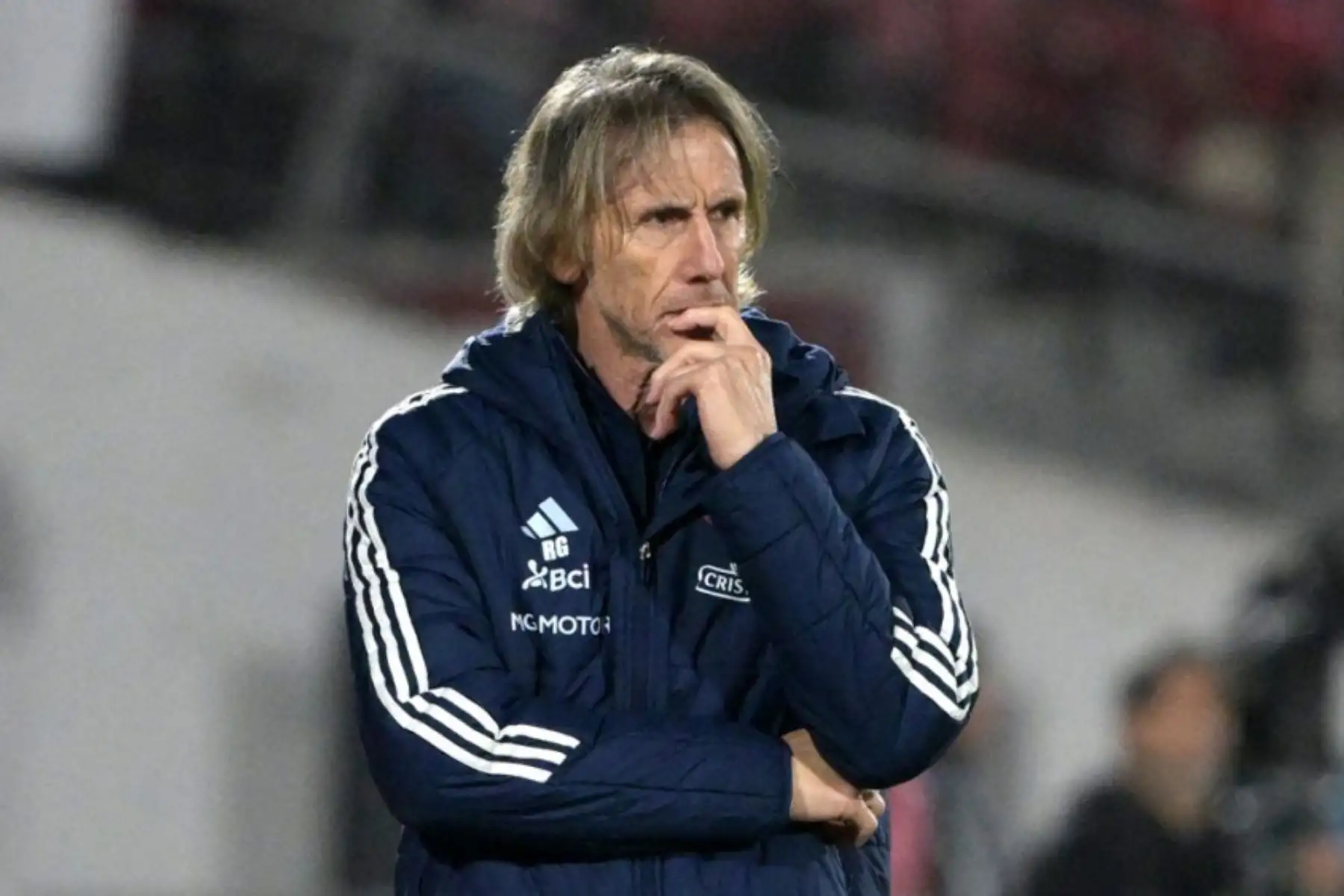 La Asociación Nacional de Fútbol Profesional (ANFP) de Chile anunció el fin del ciclo de Ricardo Gareca como director técnico de la selección tras la derrota 2-0 ante Bolivia en El Alto. Este resultado dejó a La Roja sin posibilidades de clasificar al Mundial de 2026, siendo la primera selección sudamericana eliminada. Pablo Milad, presidente de la ANFP, confirmó la decisión y agradeció el compromiso del entrenador argentino durante su gestión. Foto: AFP