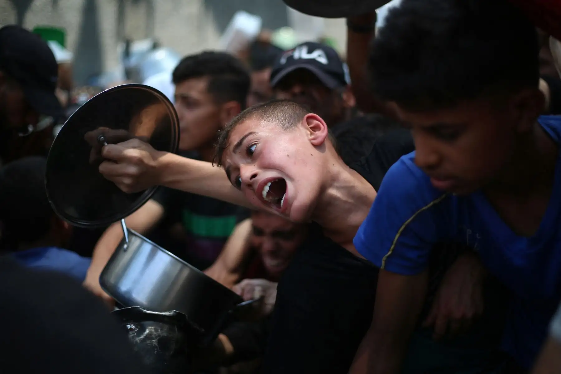 Niños palestinos esperan comida en un punto de distribución en Nuseirat, en el centro de la Franja de Gaza. Las Naciones Unidas han advertido que toda la población enfrenta el riesgo de hambruna después de que no se permitiera la entrada de ayuda durante más de dos meses. Foto: AFP
