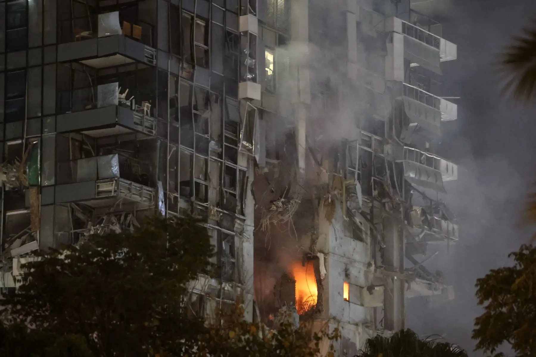 El fuego y el humo se elevan desde un edificio, alcanzado por un misil disparado desde Irán, en el centro de Tel Aviv. Foto: AFP
