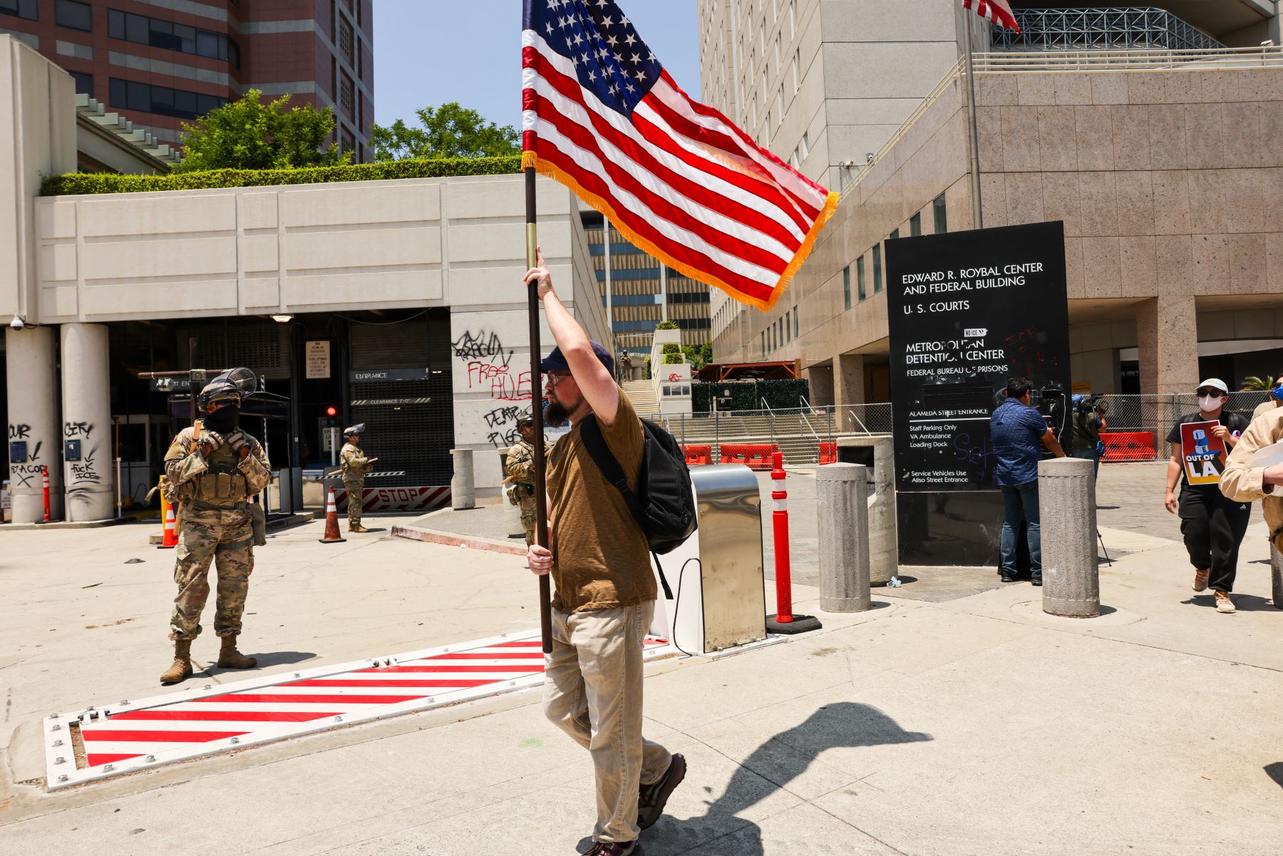 Manifestantes caminan frente a un edificio federal en Los Ángeles, California. Las manifestaciones continúan tras el inicio de una serie de redadas migratorias el pasado viernes 6 de junio. La tensión en la ciudad se mantiene alta después de que la administración Trump desplegara a la Guardia Nacional y a la Infantería de Marina en contra de la voluntad de los líderes municipales.  AFP