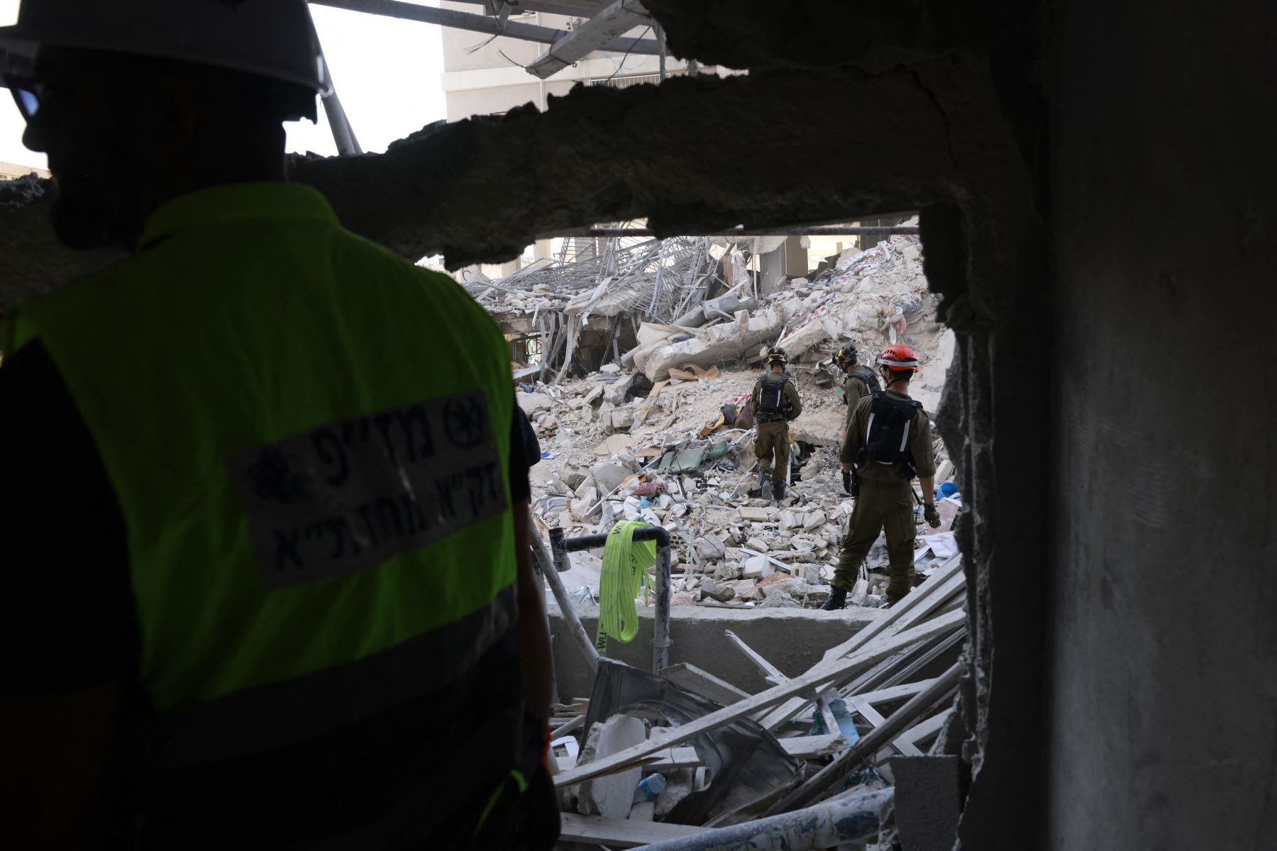 Rescatistas israelíes buscan entre los escombros en el lugar de un ataque con misiles iraníes durante la noche en Bat Yam el 15 de junio de 2025. 
Foto: AFP