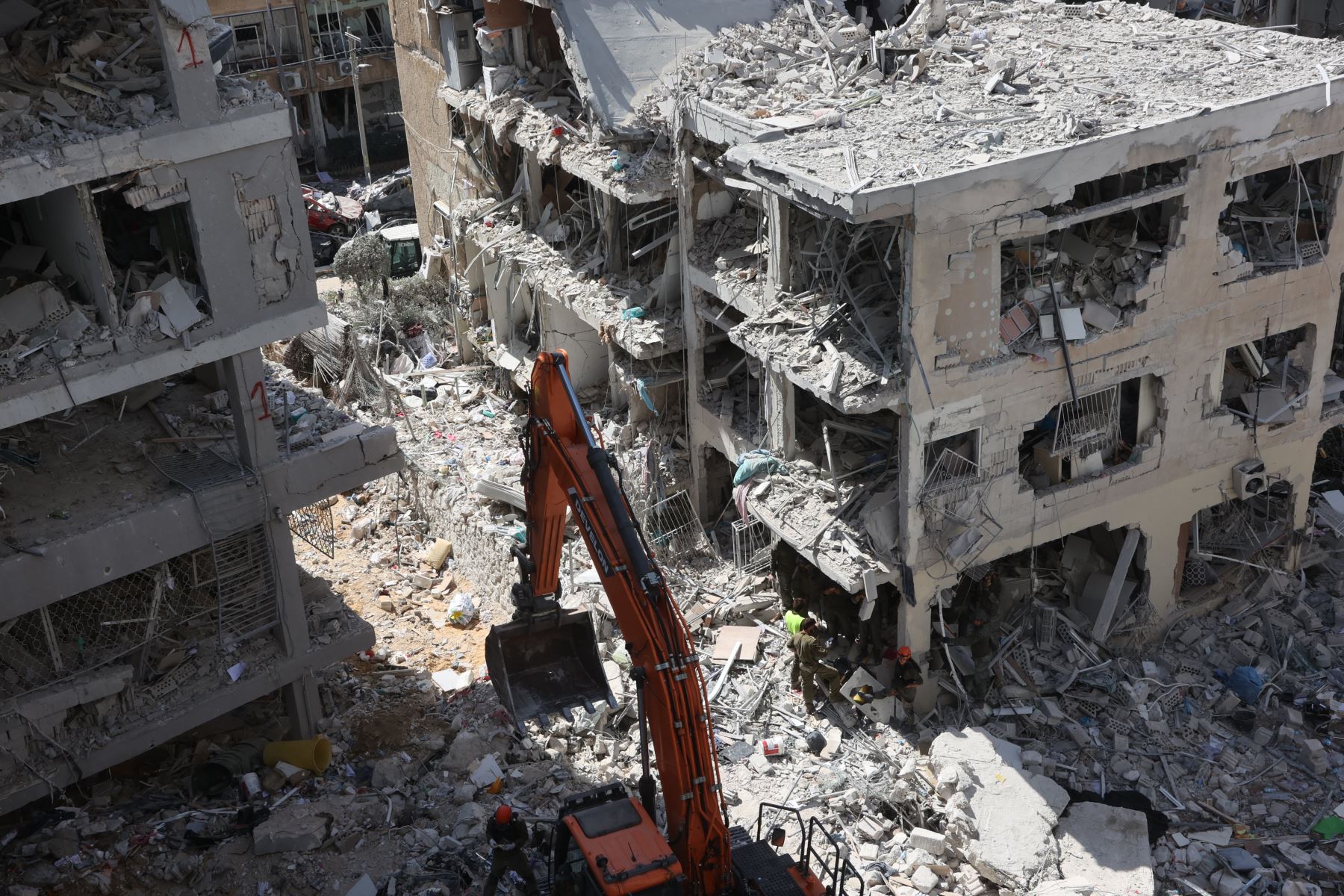 Rescatistas israelíes buscan entre los escombros en el lugar de un ataque con misiles iraníes durante la noche en Bat Yam el 15 de junio de 2025. 
Foto: AFP