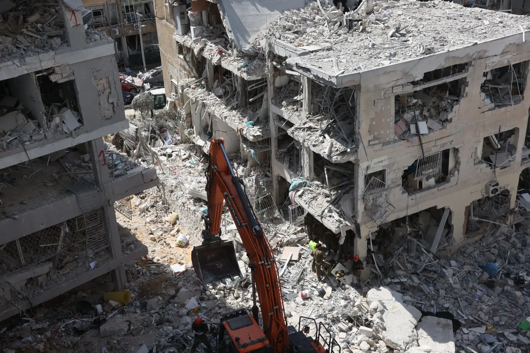 Rescatistas israelíes buscan entre los escombros en el lugar de un ataque con misiles iraníes durante la noche en Bat Yam el 15 de junio de 2025. 
Foto: AFP