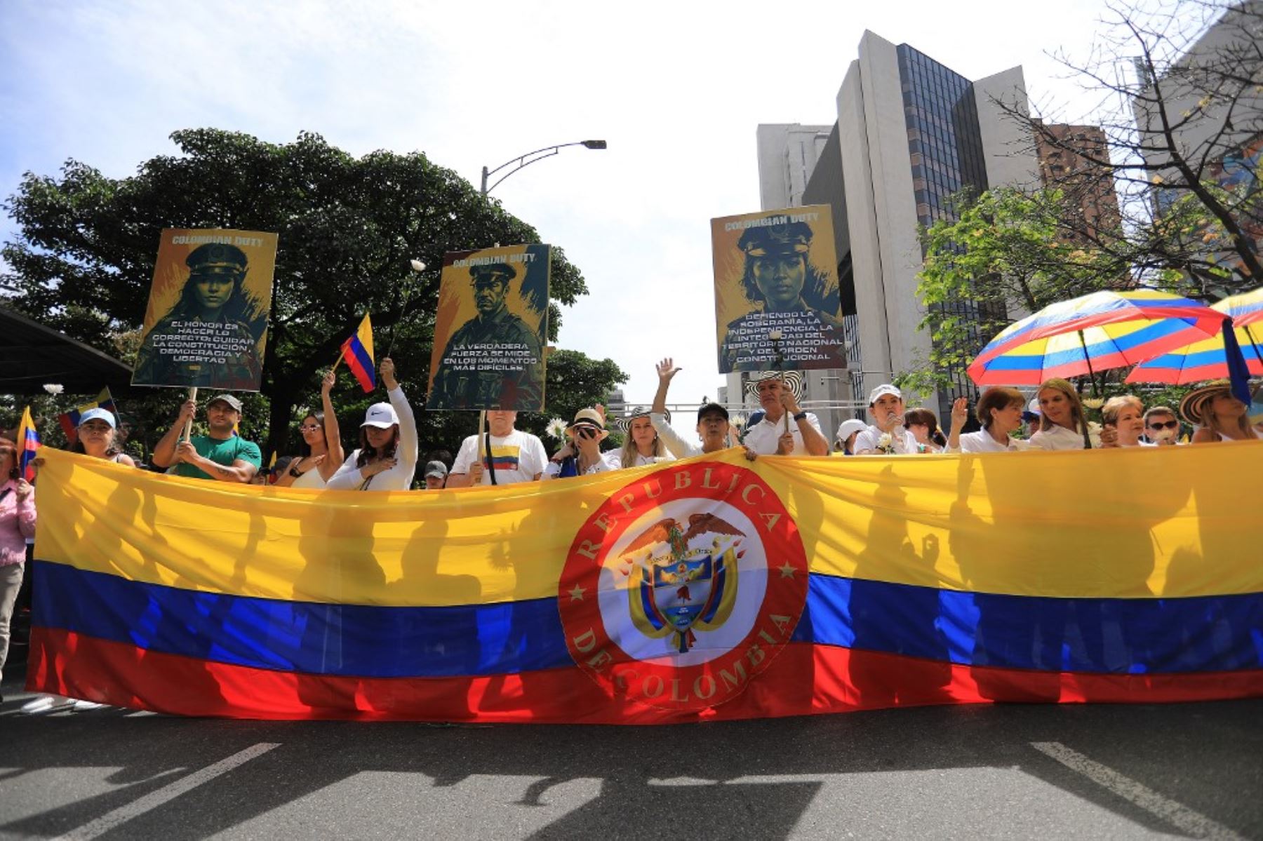 Personas sostienen una gran bandera colombiana durante la llamada "Marcha Silenciosa" para mostrar apoyo a la salud del senador Miguel Uribe Turbay y pedir paz para el país en Medellín, Colombia, el 15 de junio de 2025. Foto: AFP