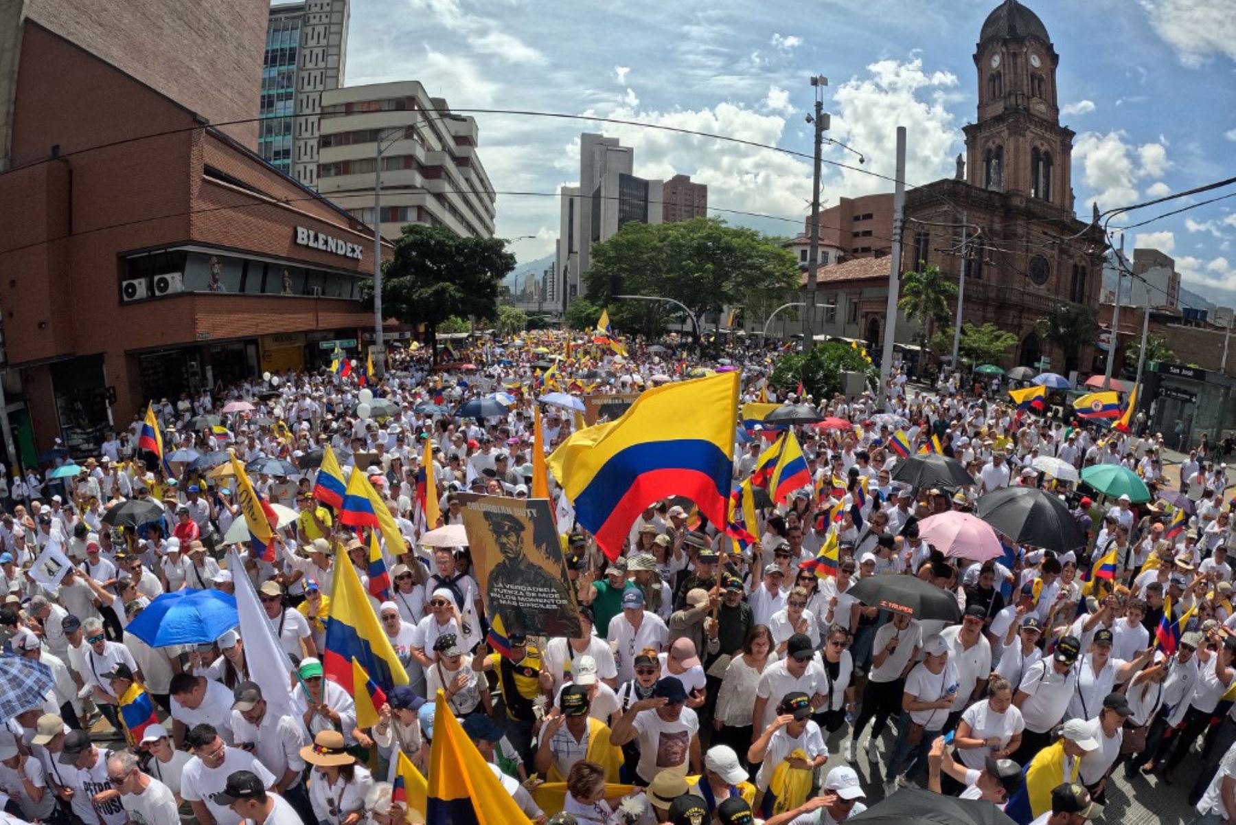Personas con camisetas blancas y banderas colombianas participan en la llamada "Marcha Silenciosa" para expresar su apoyo a la salud del senador Miguel Uribe Turbay y pedir la paz en el país en Medellín, Colombia, el 15 de junio de 2025. Foto: AFP