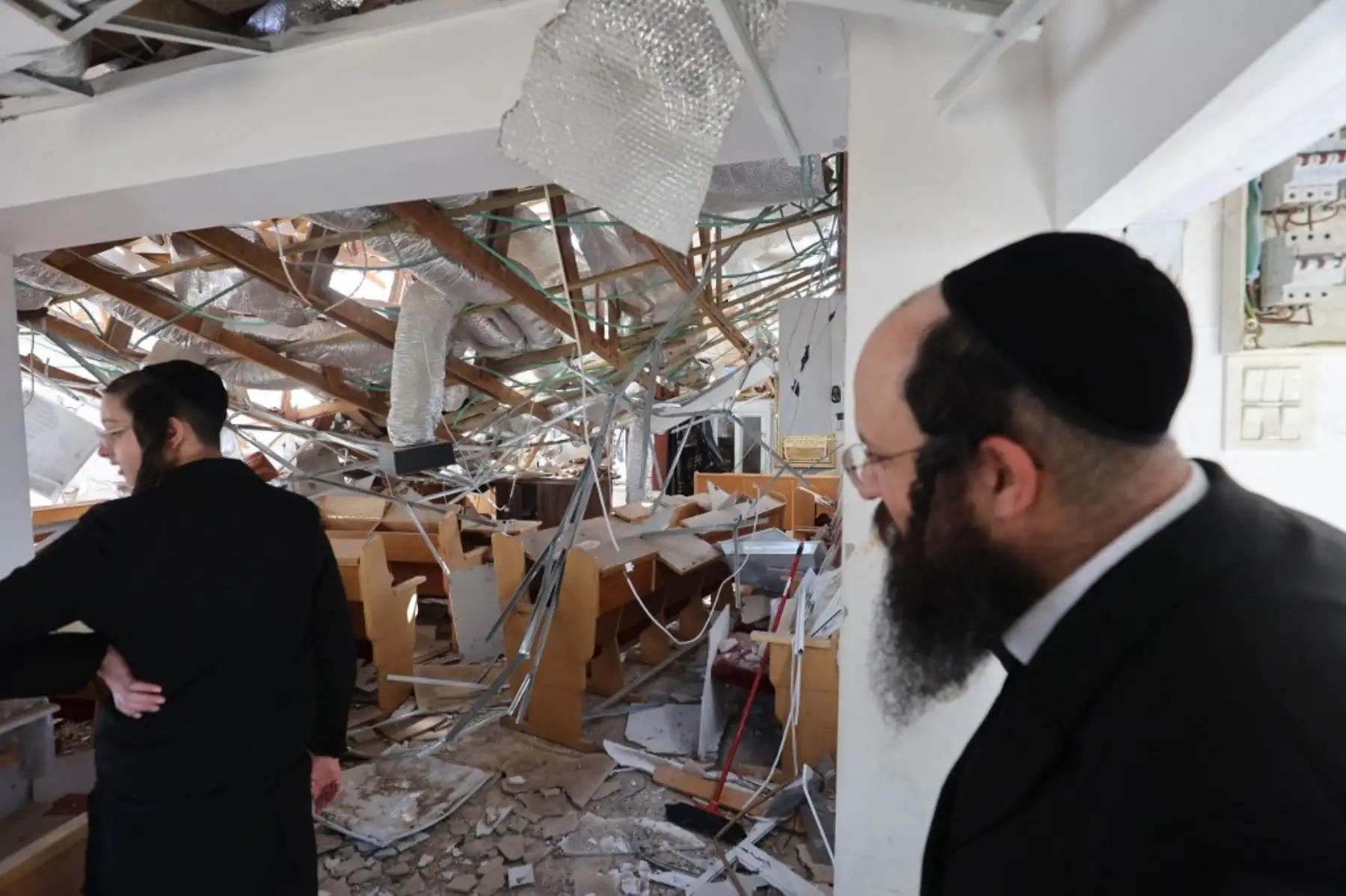 Judíos ultraortodoxos inspeccionan los daños en el lugar de un ataque con misiles iraníes en Bnei Brak. Irán desató una andanada de ataques con misiles sobre ciudades israelíes temprano el 16 de junio, después de que Israel atacara objetivos militares en el interior de Irán, y ambas partes amenazaron con una mayor devastación. Foto: AFP