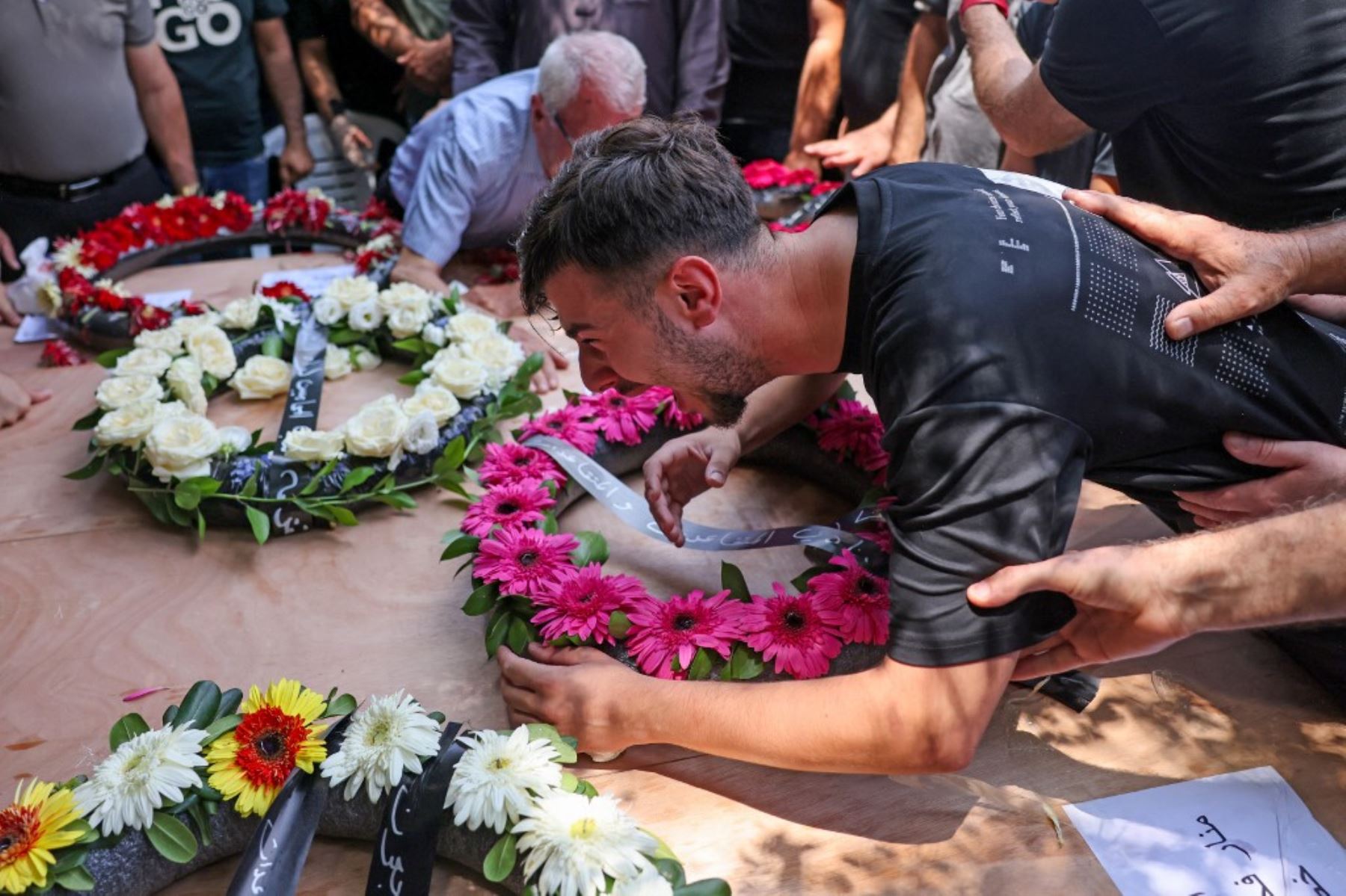 Familiares y amigos lloran los ataúdes de las víctimas de un ataque con misiles iraníes que destruyó un edificio de tres plantas en la ciudad de Tamra, en el norte de Israel, el fin de semana, y causó la muerte de cuatro mujeres, durante un funeral celebrado en Tamra. Foto: AFP