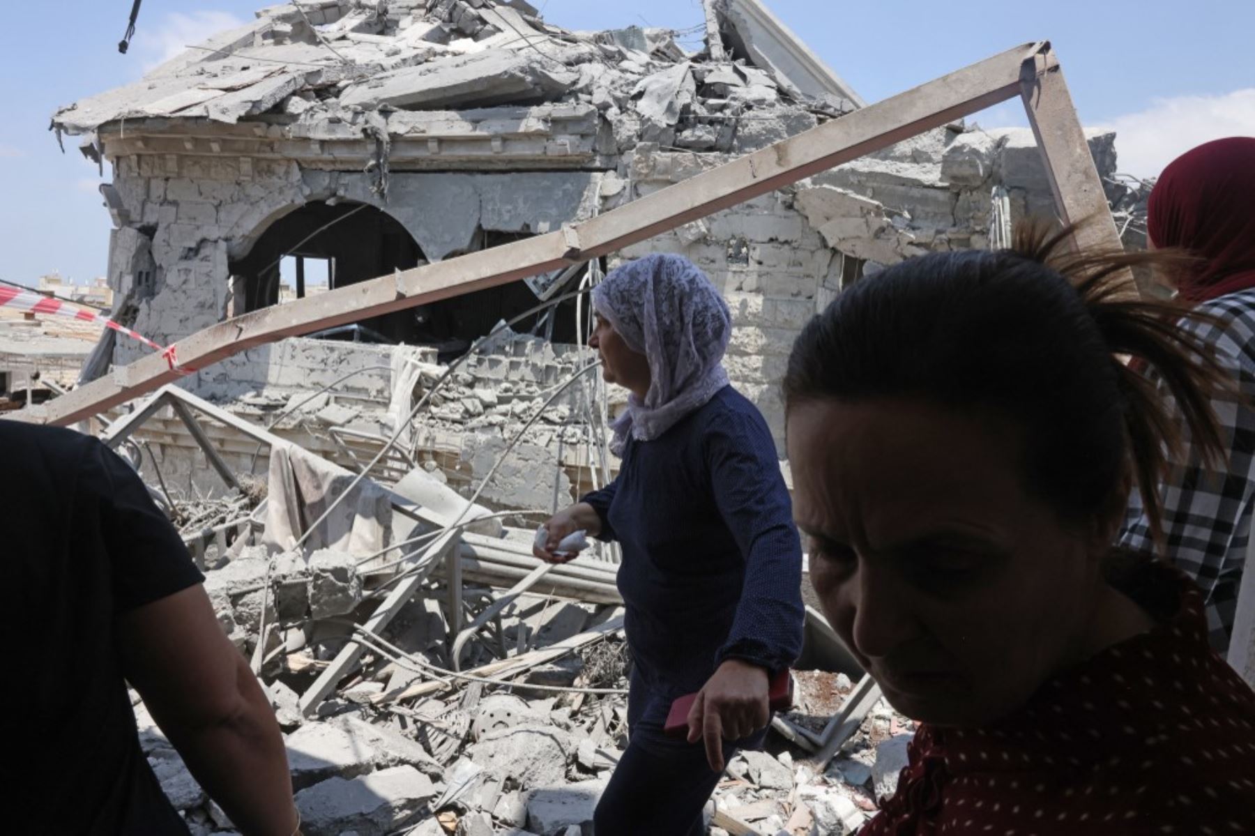 Mujeres reaccionan mientras observan la destrucción en la ciudad de Tamra, en el norte de Israel. Foto: AFP