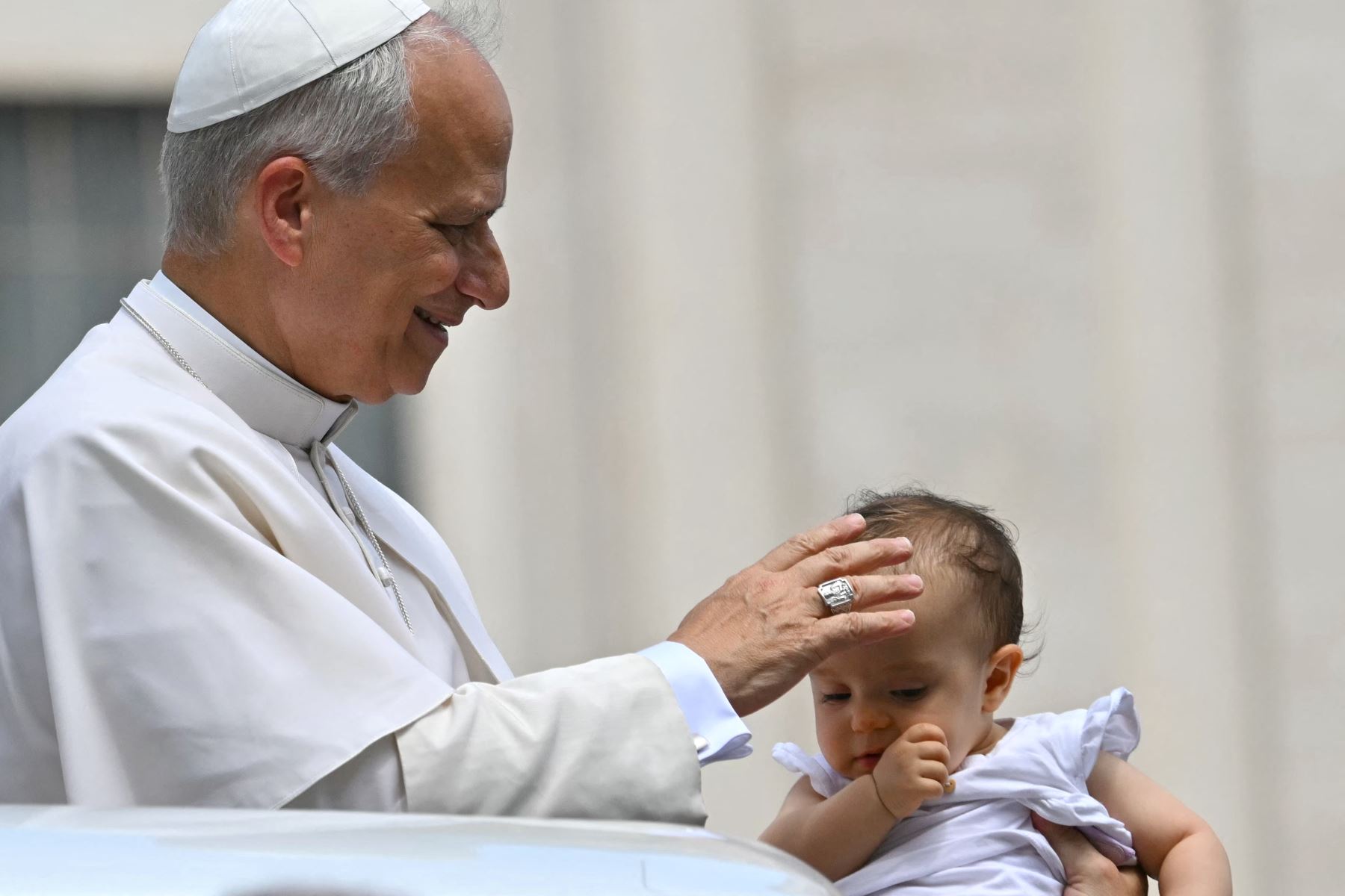 El Papa León XIV bendice a un bebé al final de una audiencia general semanal en la Plaza de San Pedro en el Vaticano. AFP