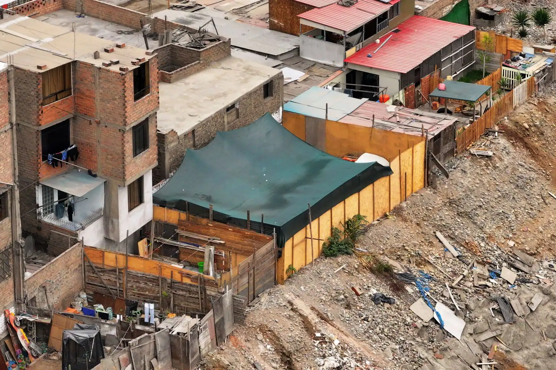 A la altura del cruce de las avenidas Morales Duárez y Universitaria en el Callao, por donde pasa el río Rímac, se observan algunas casas de material noble y precario construidas en los bordes del cause, las cuales en un eventual movimiento sísmico de gran magnitud podrían colapsar y poner en riesgo la vida de sus residentes. Foto: ANDINA/Daniel Bracamonte
