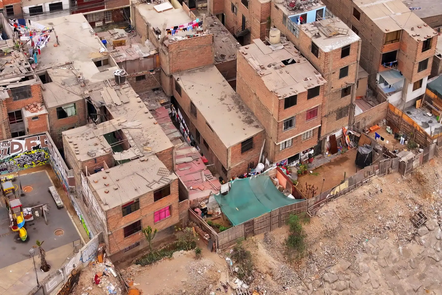 A la altura del cruce de las avenidas Morales Duárez y Universitaria en el Callao, por donde pasa el río Rímac, se observan algunas casas de material noble y precario construidas en los bordes del cause, las cuales en un eventual movimiento sísmico de gran magnitud podrían colapsar y poner en riesgo la vida de sus residentes. Foto: ANDINA/Daniel Bracamonte
