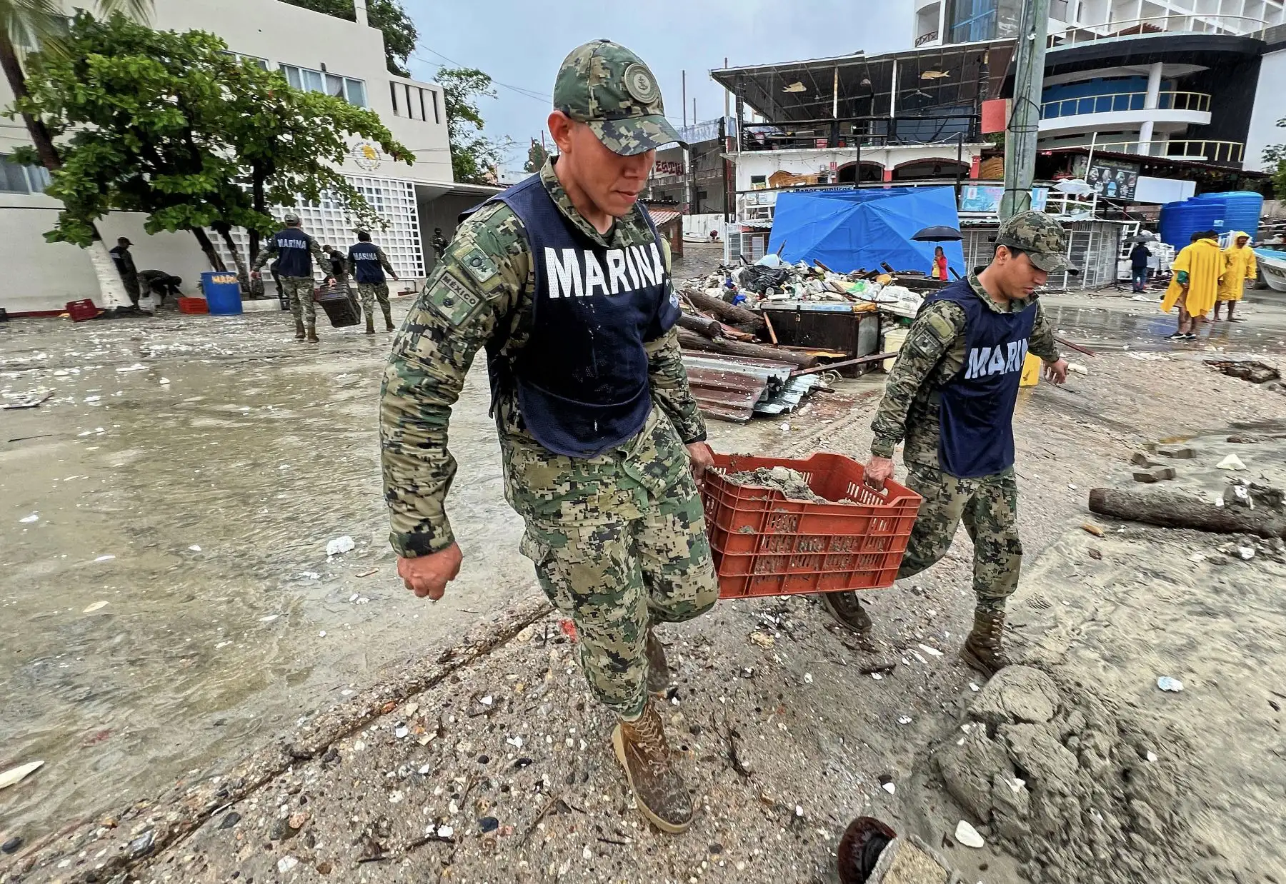 Elementos de la Armada de México ayudan en tareas de reparación tras el paso del huracán Erick en Bahía Principal, Puerto Escondido. AFP