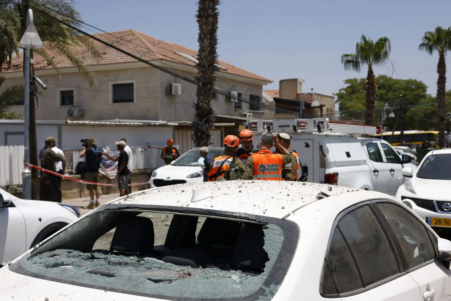 Soldados israelíes y personal de primera respuesta inspeccionan los daños en el lugar de un ataque iraní en Beit She