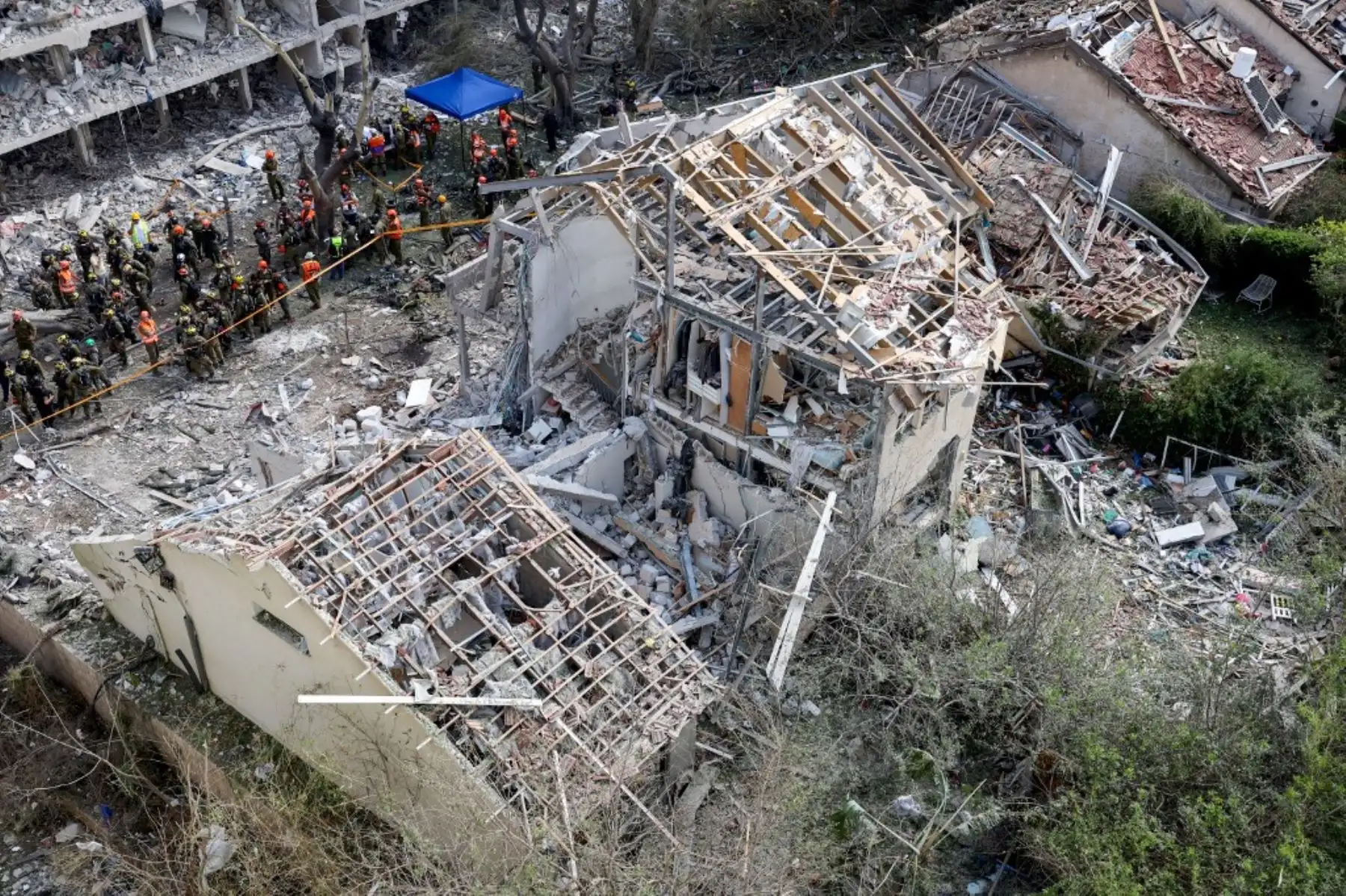 Fuerzas de seguridad israelíes y personal de primera respuesta se reúnen en el lugar de un ataque iraní que impactó un barrio residencial en la zona de Ramat Aviv, Tel Aviv. Foto: AFP