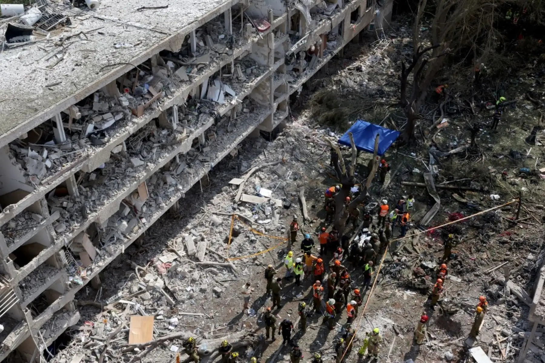 Fuerzas de seguridad israelíes y personal de primera respuesta se reúnen en el lugar de un ataque iraní que impactó un barrio residencial en la zona de Ramat Aviv, Tel Aviv. Foto: AFP