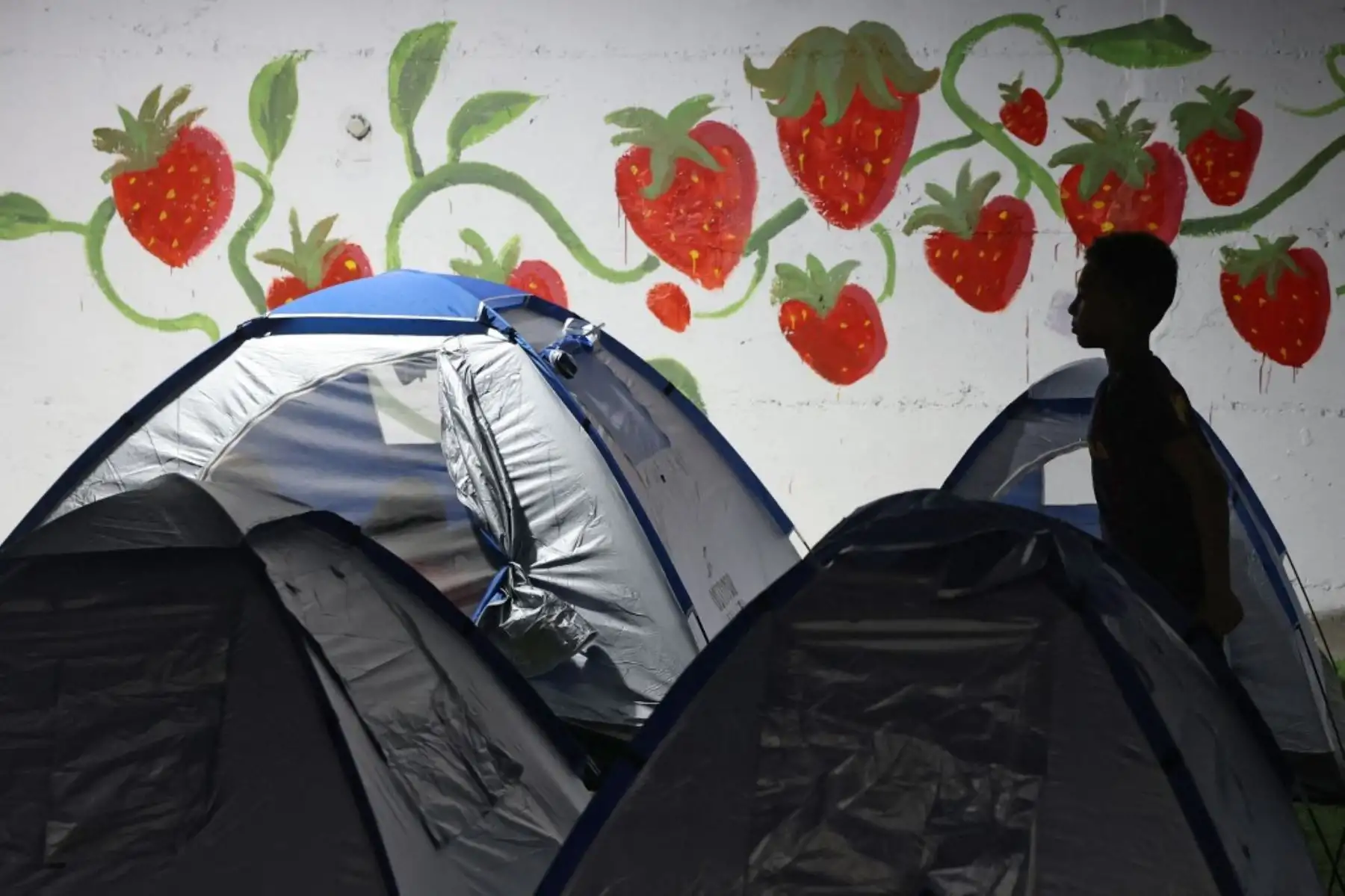Un niño camina fuera de unas tiendas de campaña mientras la gente se refugia en una estación de autobuses de Tel Aviv. Foto: AFP