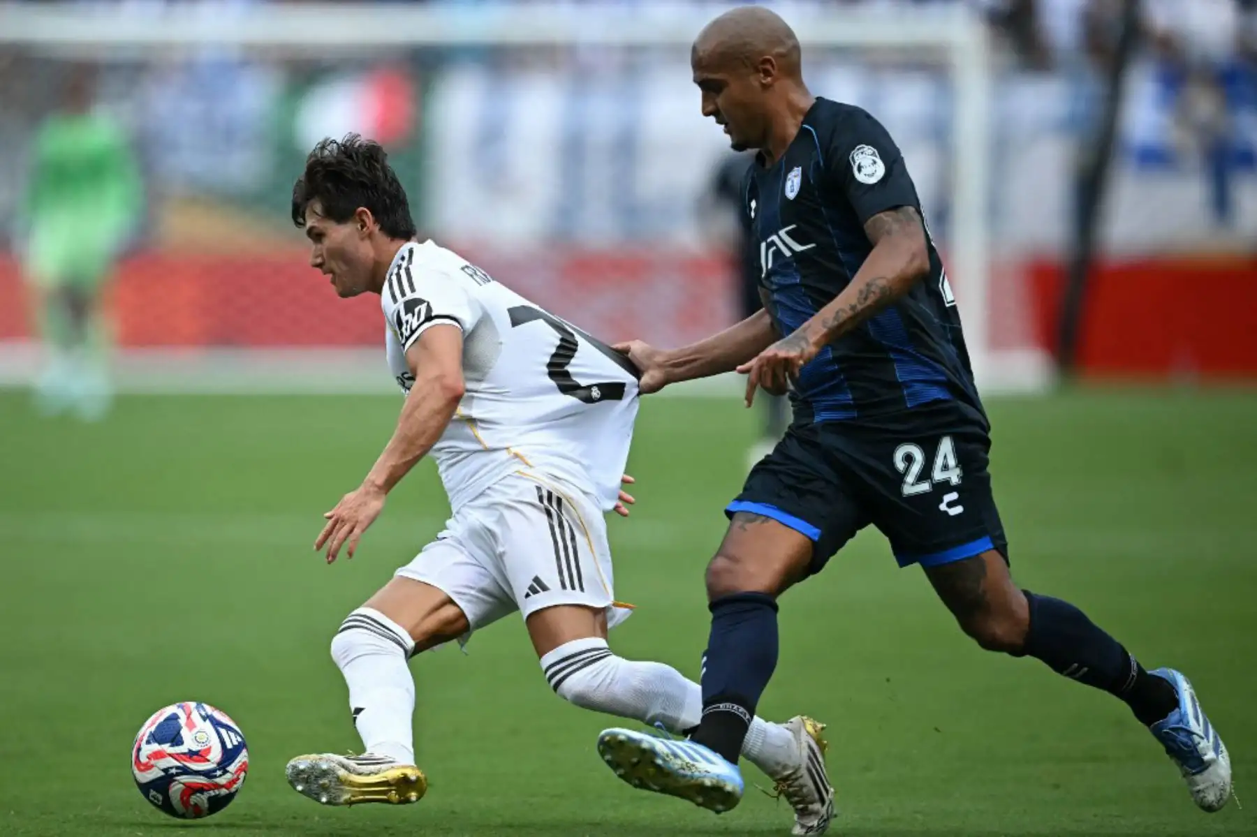 El defensa español del Real Madrid, Francisco García, y el defensa mexicano del Pachuca, Luis Rodríguez, luchan por el balón durante el partido de fútbol del Grupo H de la Copa Mundial de Clubes de la FIFA 2025 entre el Real Madrid de España y el Pachuca de México en el estadio Bank of America en Charlotte. Foto: AFP