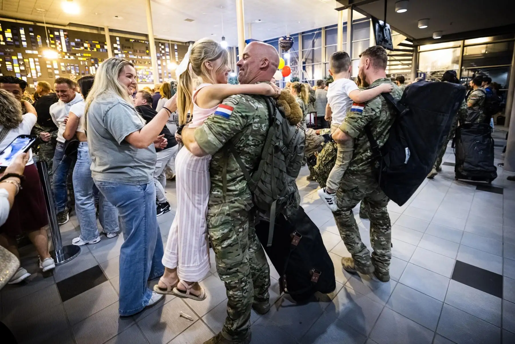 Soldados holandeses saludan a sus seres queridos tras desembarcar de un avión que transportaba setenta soldados atrapados en Irak por la guerra entre los vecinos Irán e Israel, tras aterrizar en el aeropuerto de Eindhoven, Países Bajos. Foto: AFP