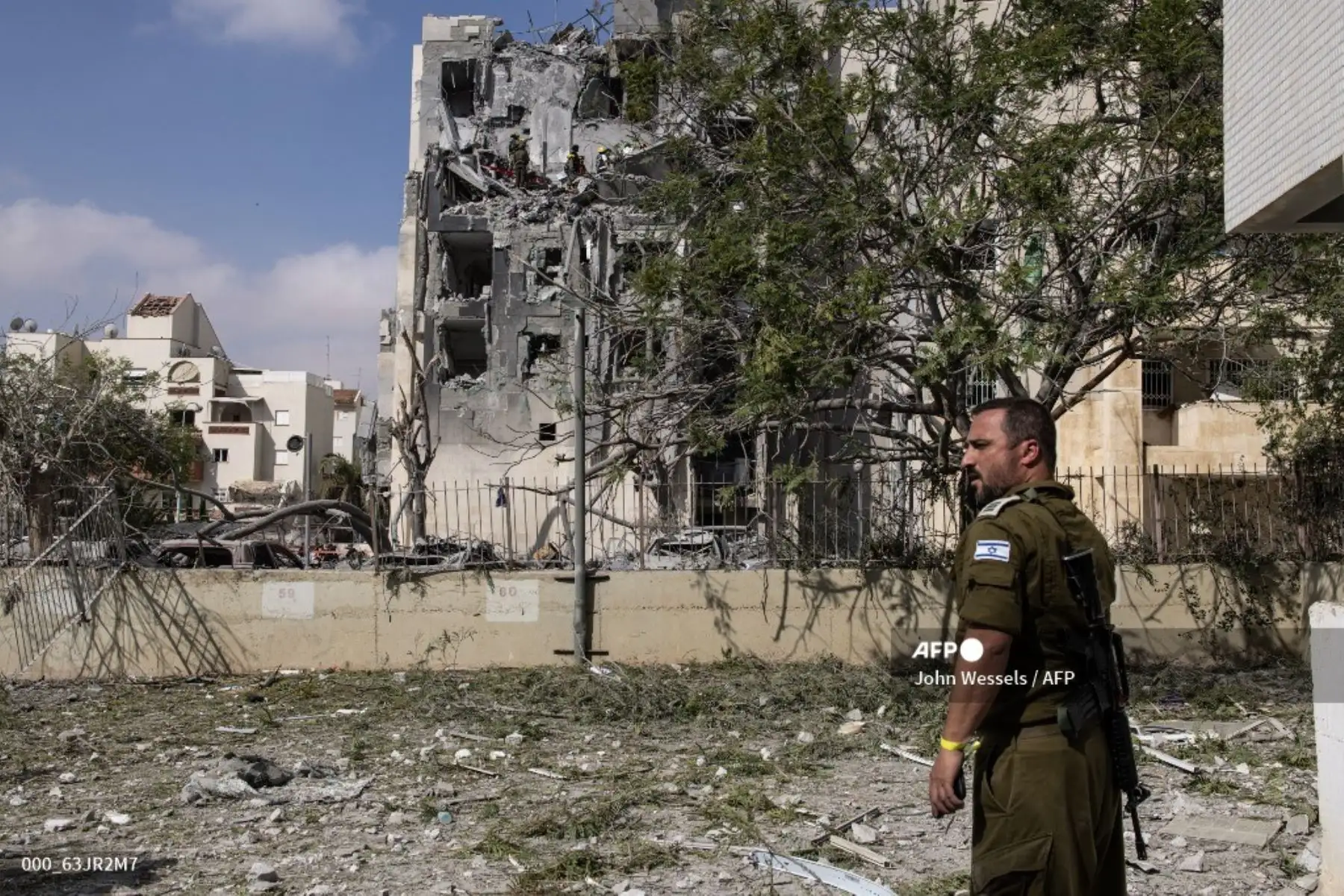 Un miembro de las fuerzas de seguridad israelíes monta guardia mientras los rescatistas buscan víctimas entre los escombros de un edificio impactado por un misil iraní en Beersheba, al sur de Israel, el 24 de junio de 2025.  Foto:  AFP