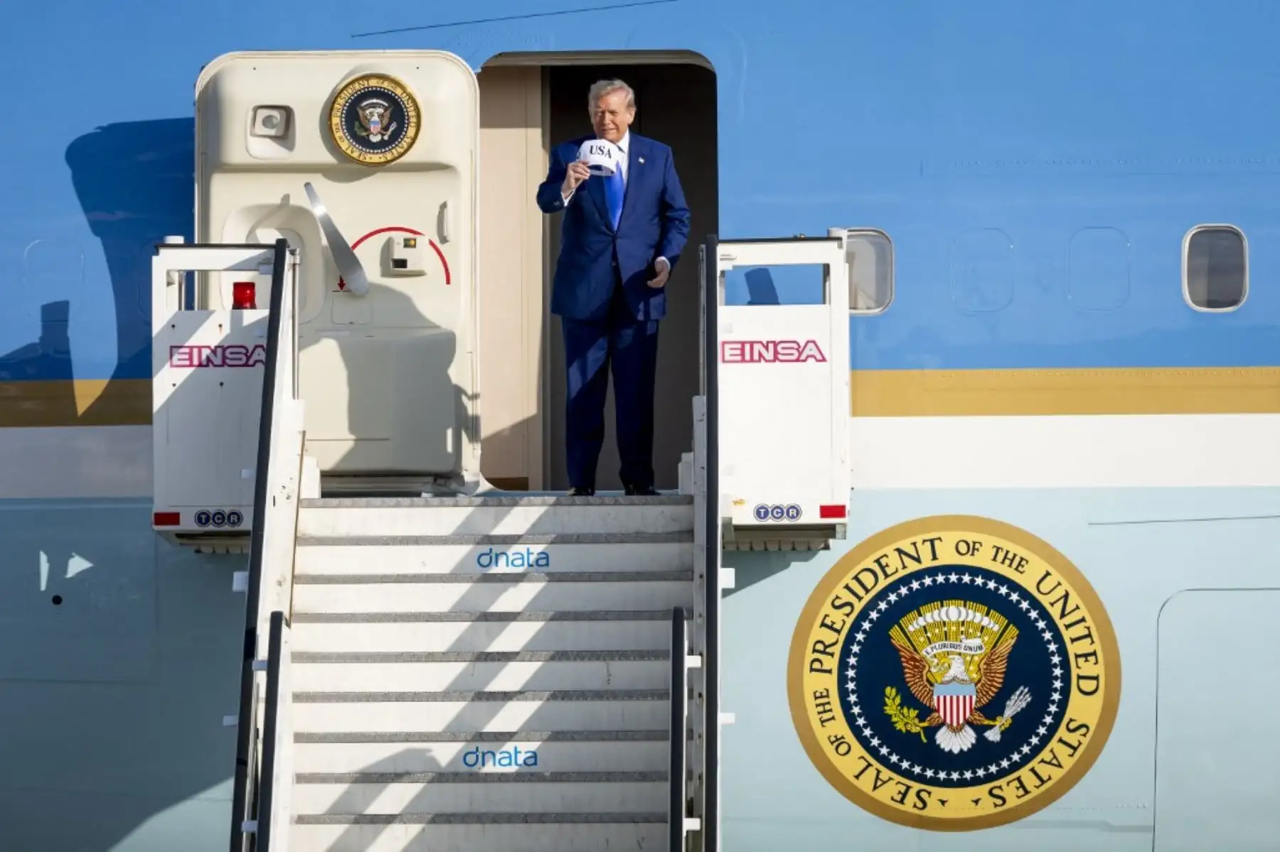 Trump, que llegó vestido con un traje y corbata azul y con una gorra blanca con las letras USA y la bandera estadounidense, ha llegado solo a Países Bajos, sin la compañía de Melania Trump. Foto: AFP